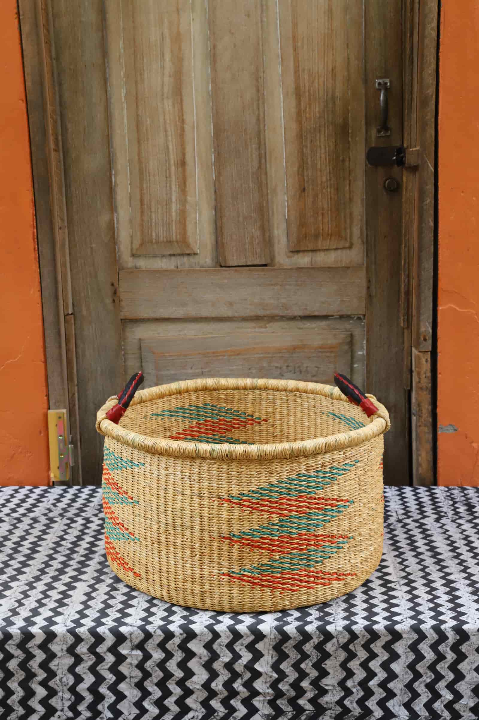 Woven Tub (Medium) handwoven in Ghana sitting on black and white cloth with wooden door background