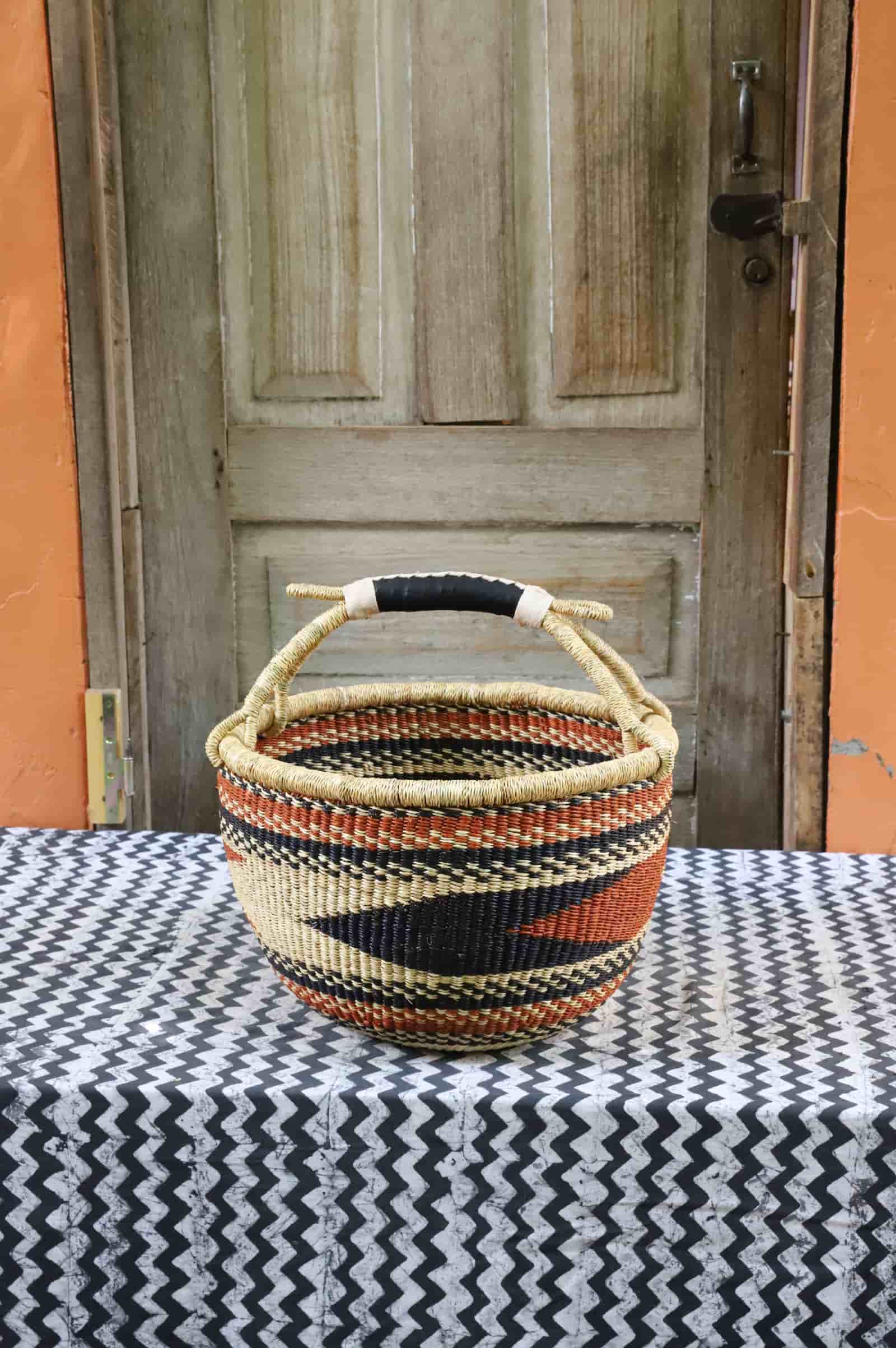 Large round Bolga basket in black, natural and terracotta diagonal zigzag with a black leather handle