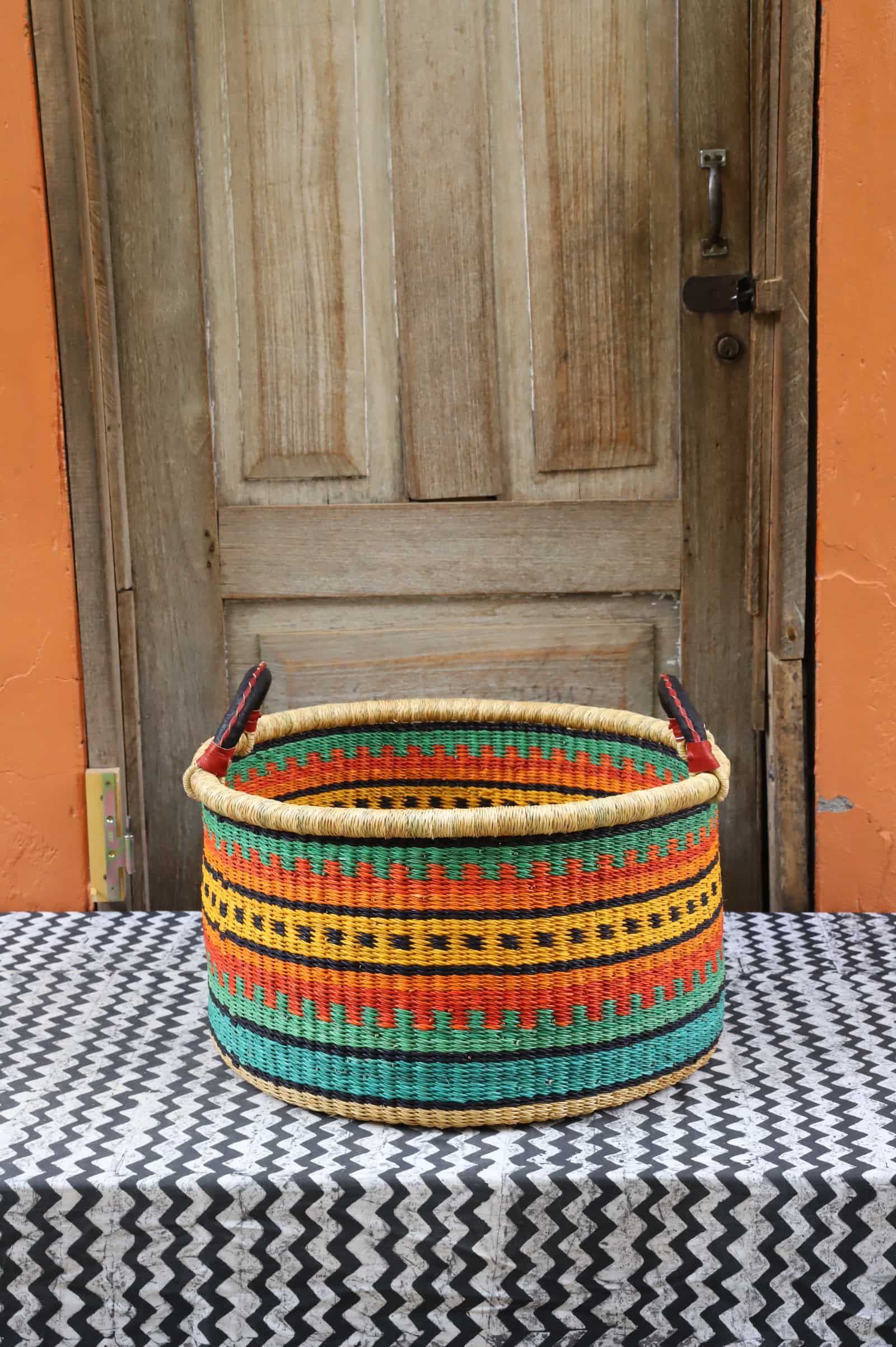 Woven Tub (Medium) handwoven in Ghana sitting on black and white cloth with wooden door background