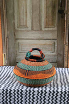 Large pot storage basket in burnt orange and teal bands with black geometric detail