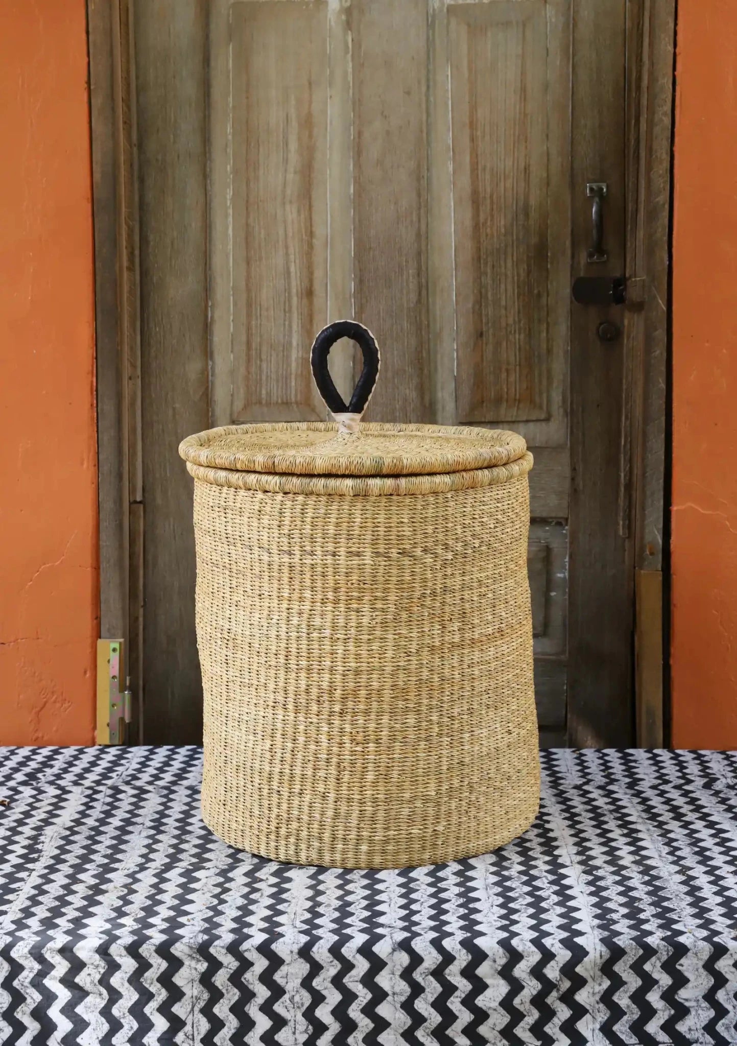 Lidded Laundry Basket with coil (Medium) by The Baba Tree. Handwoven elephant grass with leather handle. Premium Bolgatanga artisan decor.