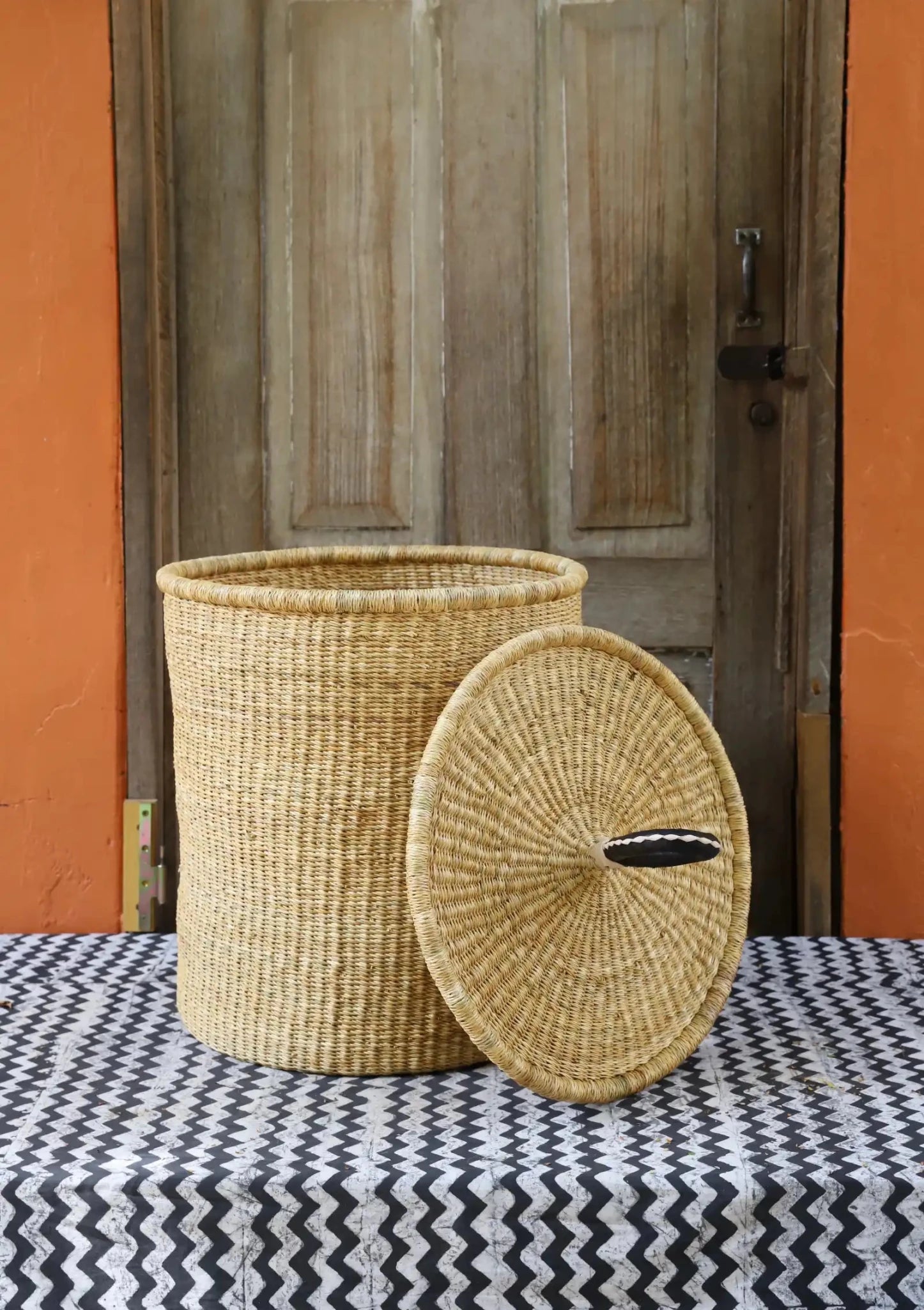 Lidded Laundry Basket with coil (Medium) by The Baba Tree. Handwoven elephant grass with leather handle. Premium Bolgatanga artisan decor.