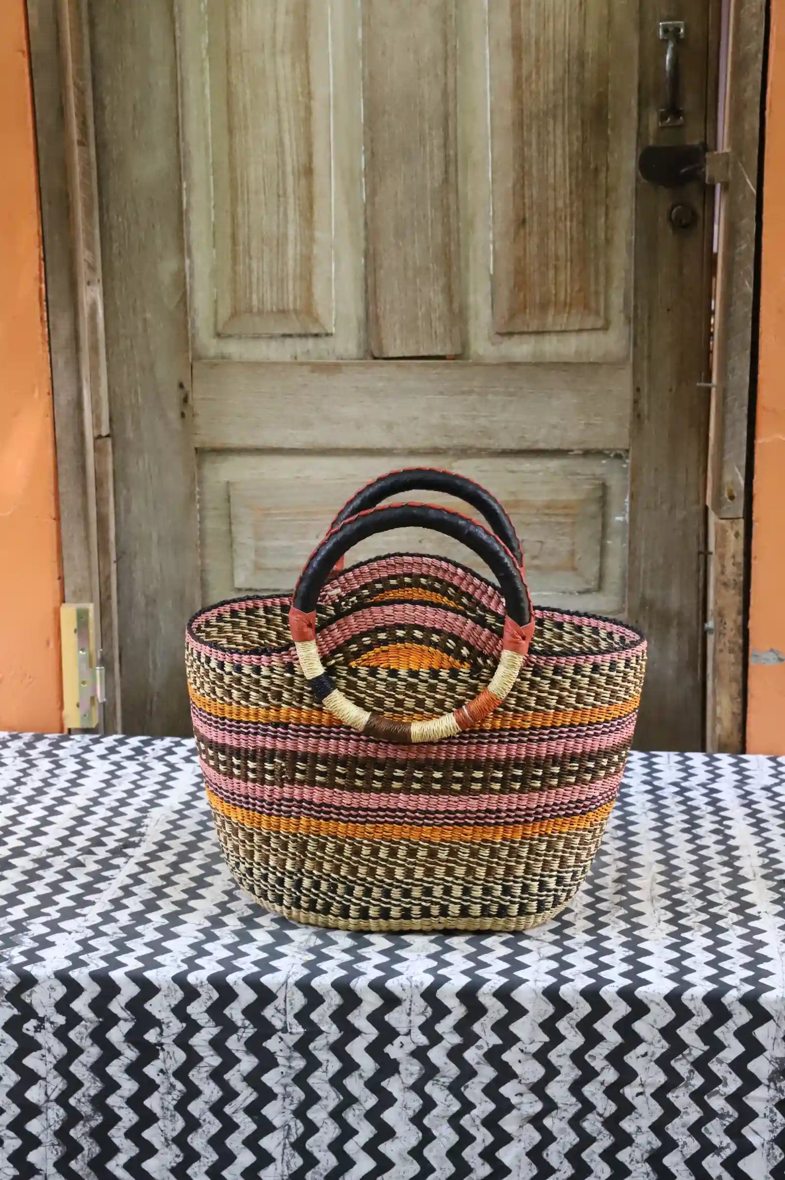 Naughty George weekend bag: dark stripe body in black, pink and orange with leather handles