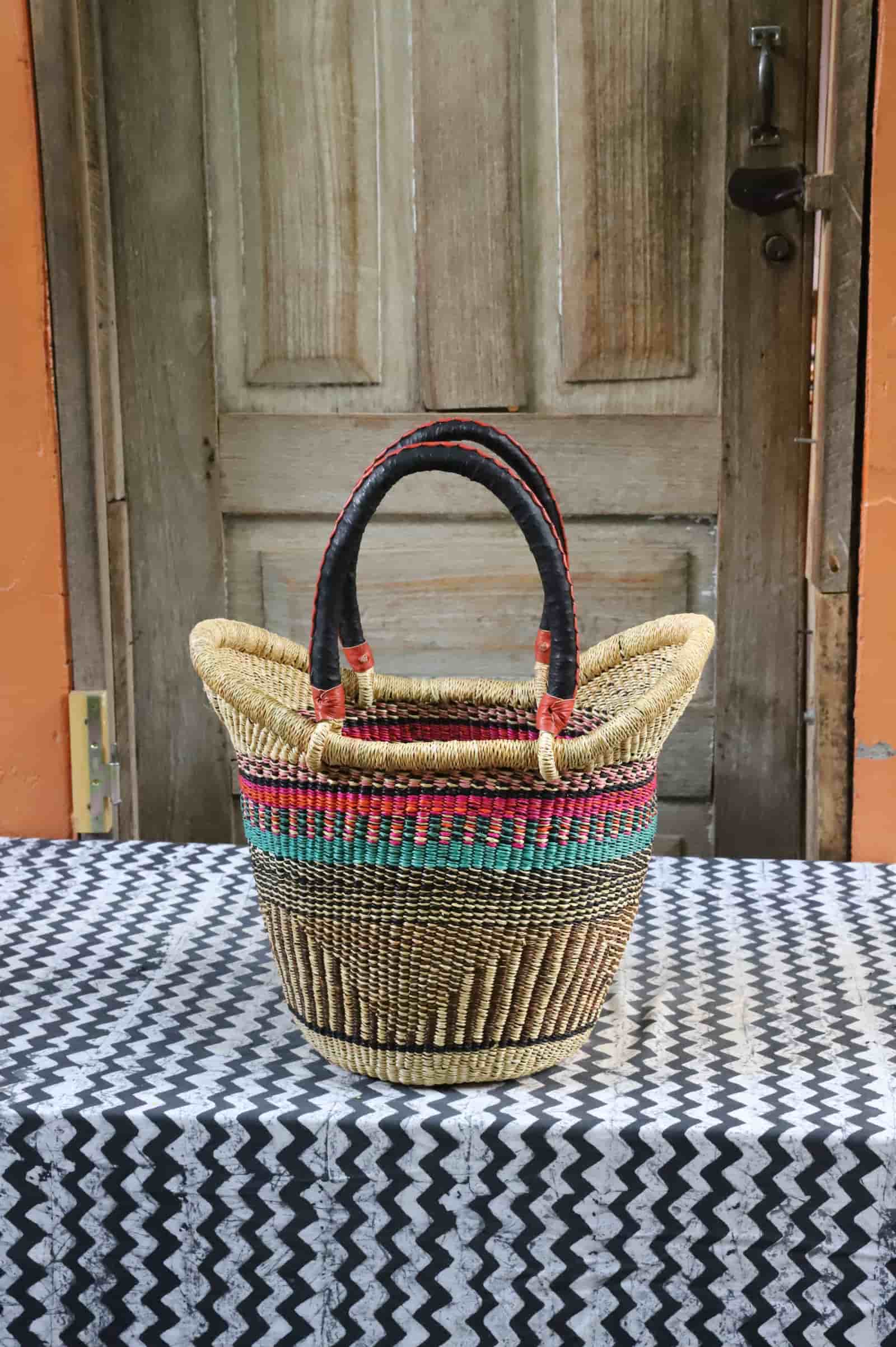 Nyariga shopping basket in natural straw with pink and teal stripe band, dark leather loop handles