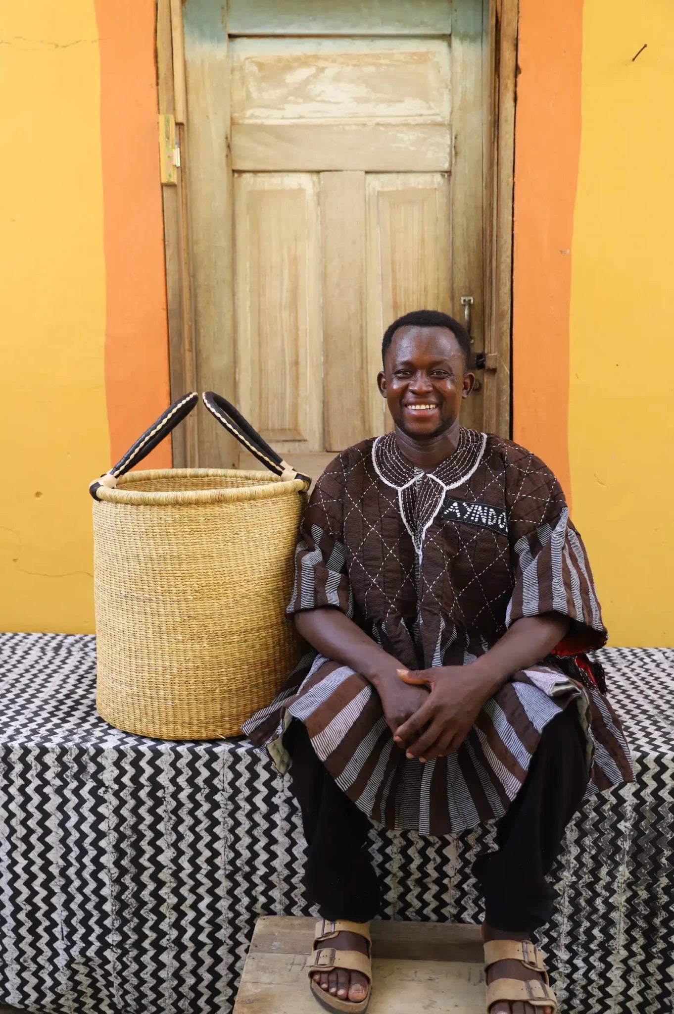 Open Laundry Basket (Medium) by The Baba Tree. Handwoven elephant grass storage with leather handles. Bolgatanga artisan decor.
