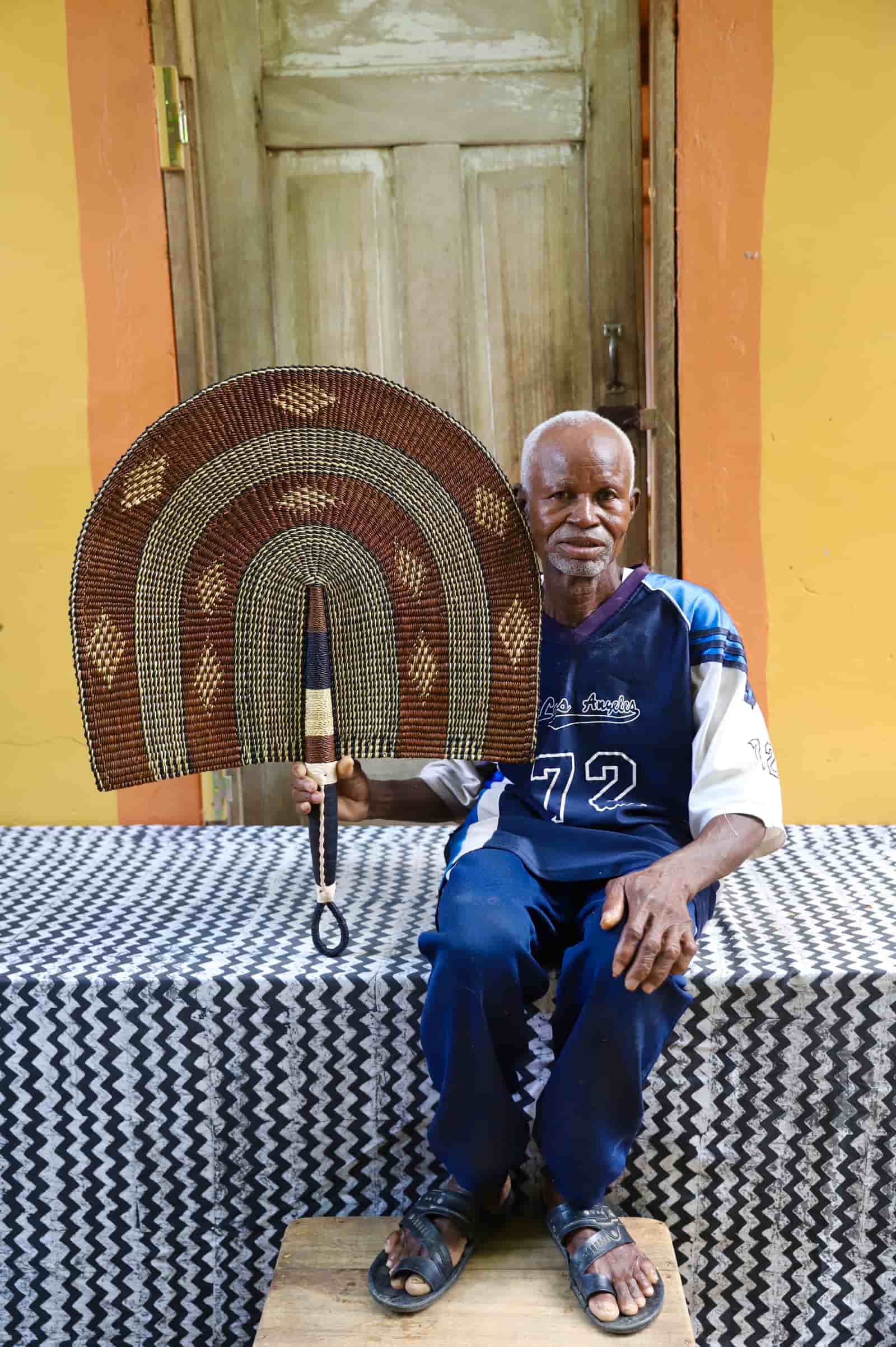Man holding Naba Penga wall décor in brown and cream with diamond motifs
