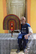 Man holding Naba Penga rainbow arch wall décor with multicolour spot pattern