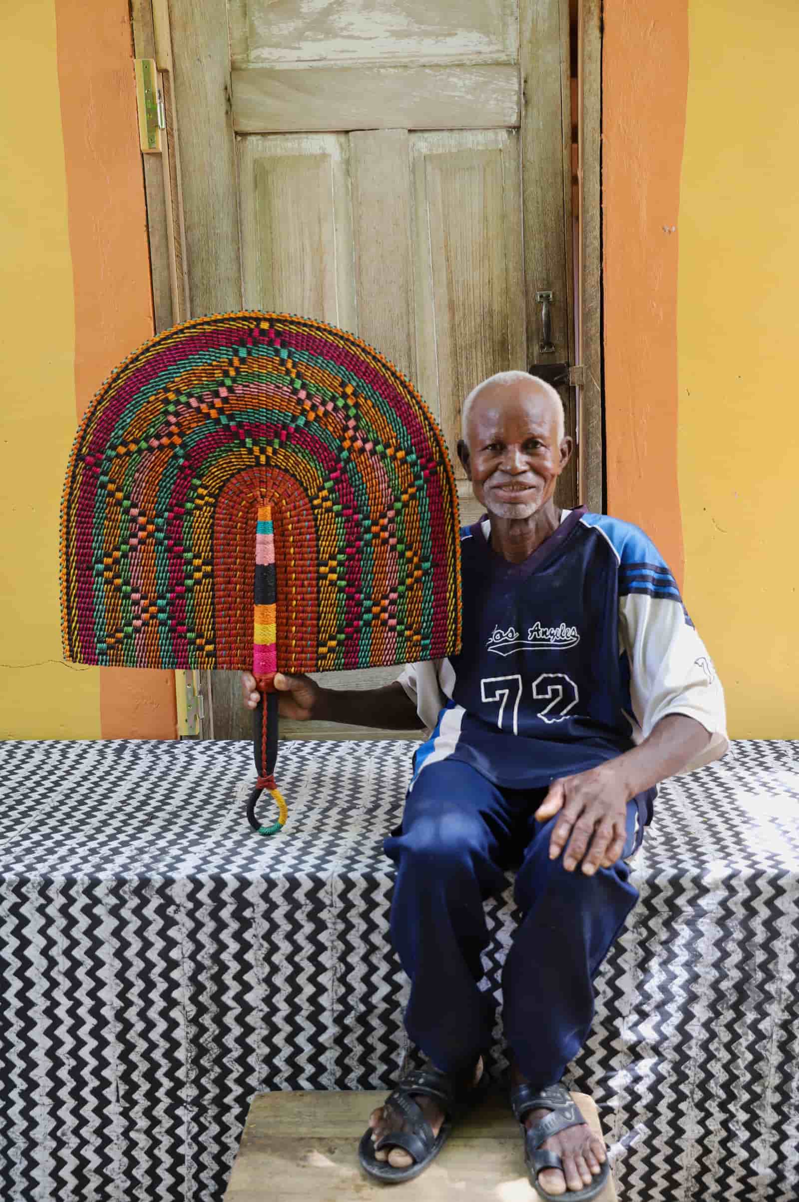 Man holding Naba Penga rainbow arch wall décor with multicolour spot pattern