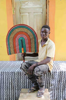 Man holding Naba Penga rainbow arch wall décor in teal, terracotta and pink
