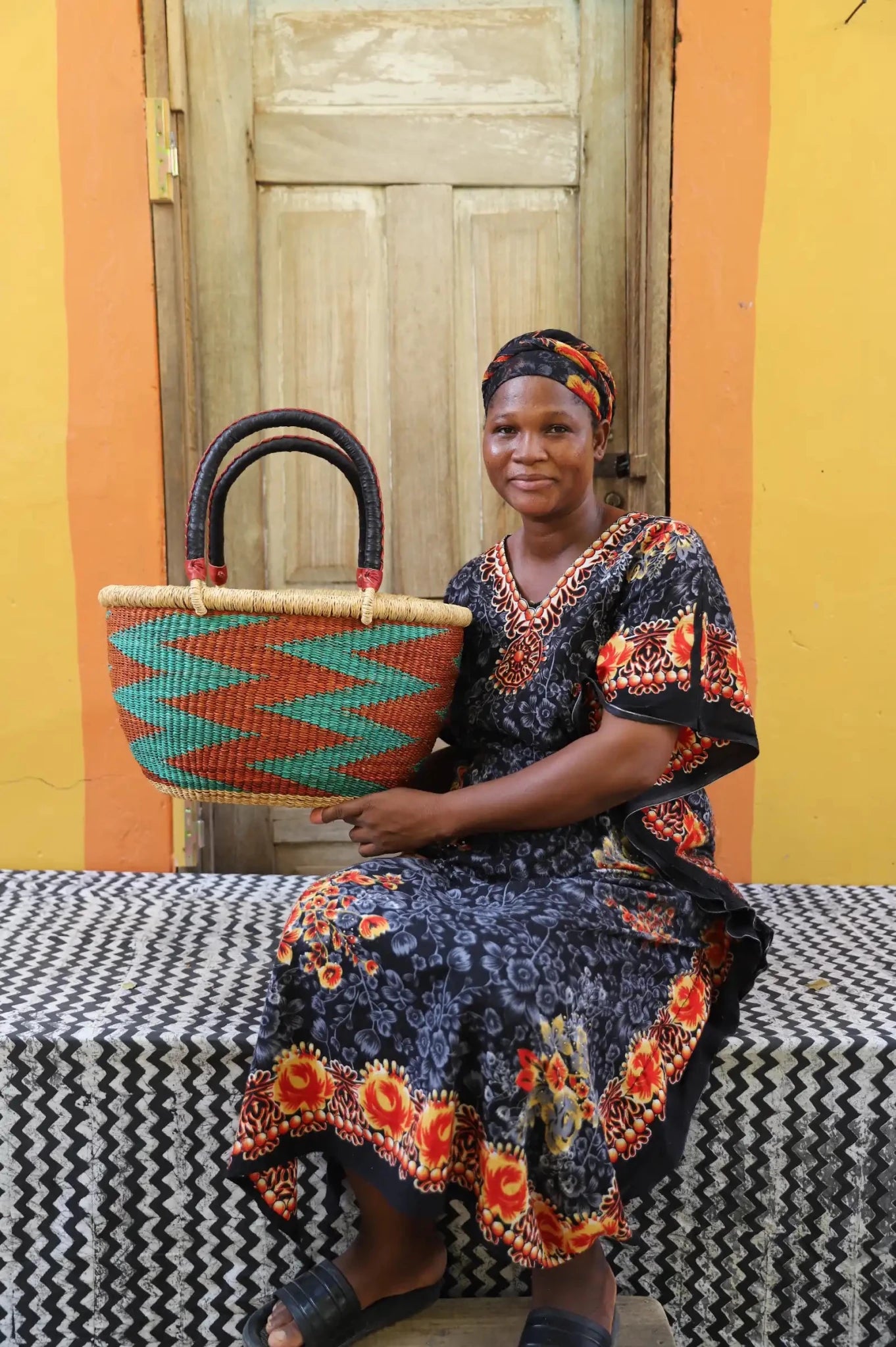 Woman holding large Oval Shopping Basket in red with teal chevron zigzag, dark leather handles