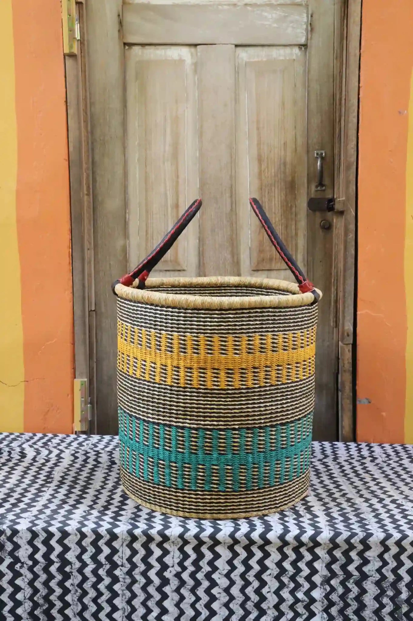 Open Laundry Basket (Large) by The Baba Tree. Handwoven elephant grass storage with leather handles. Bolgatanga artisan decor.