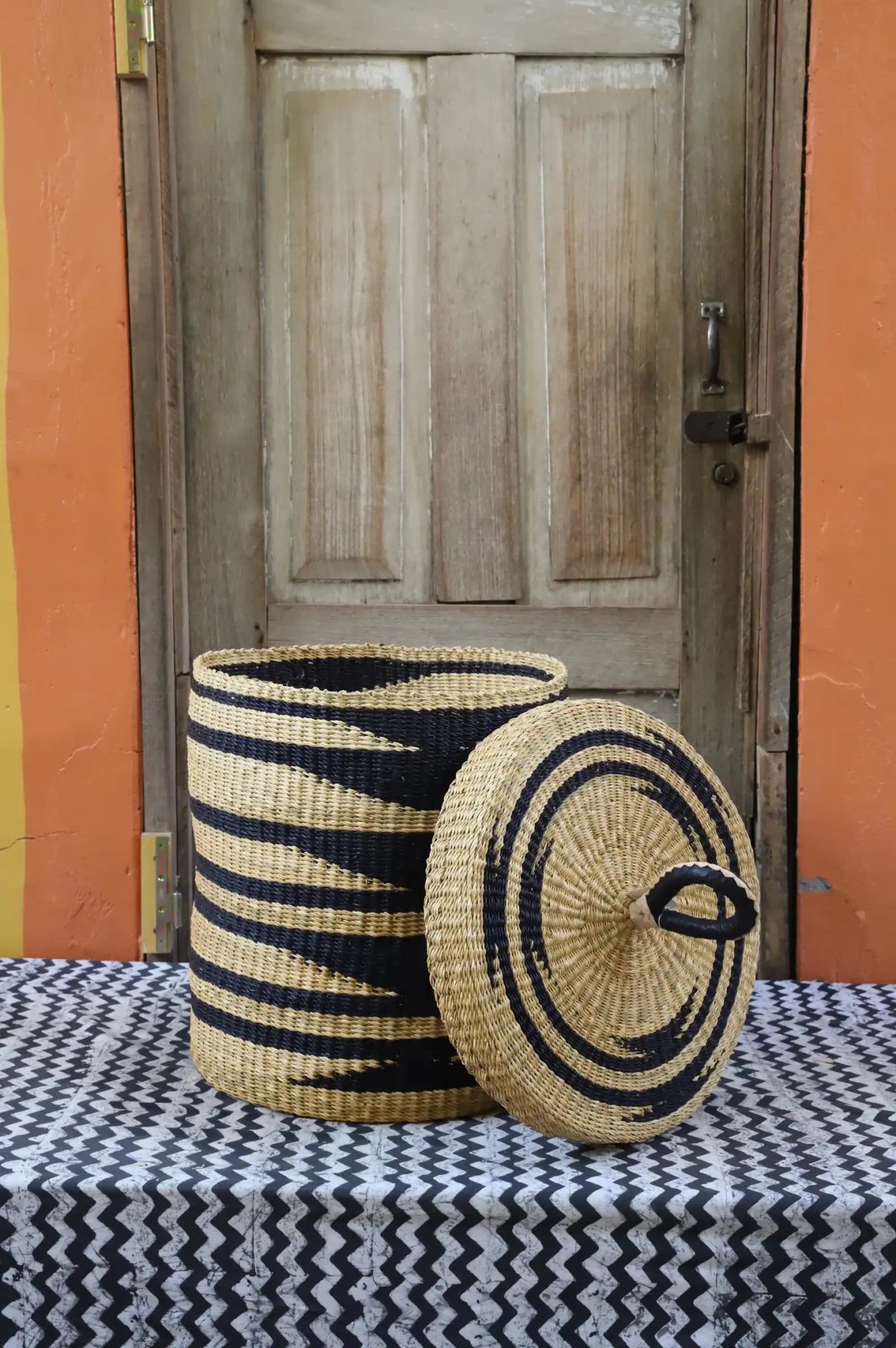 Lidded Laundry Basket  (Small) by The Baba Tree. Handwoven elephant grass
with leather handle. Premium Bolgatanga artisan decor.