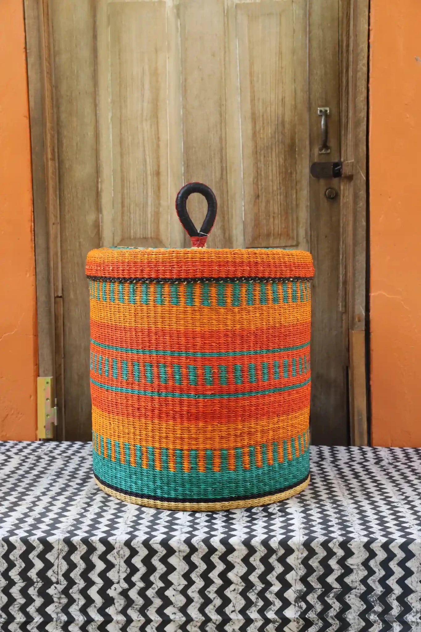 Lidded Laundry Basket (Large) by The Baba Tree. Handwoven elephant grass with leather handle. Premium Bolgatanga artisan decor.