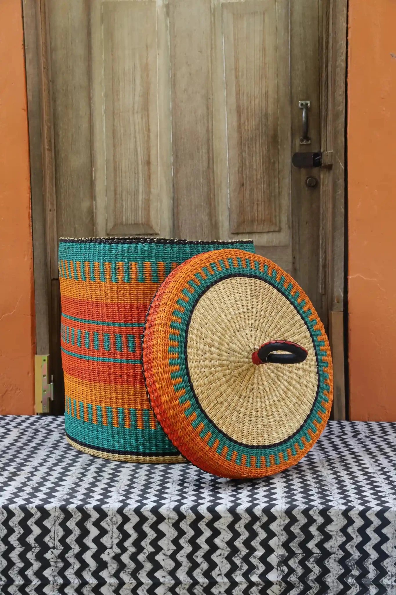 Lidded Laundry Basket (Large) by The Baba Tree. Handwoven elephant grass with leather handle. Premium Bolgatanga artisan decor.