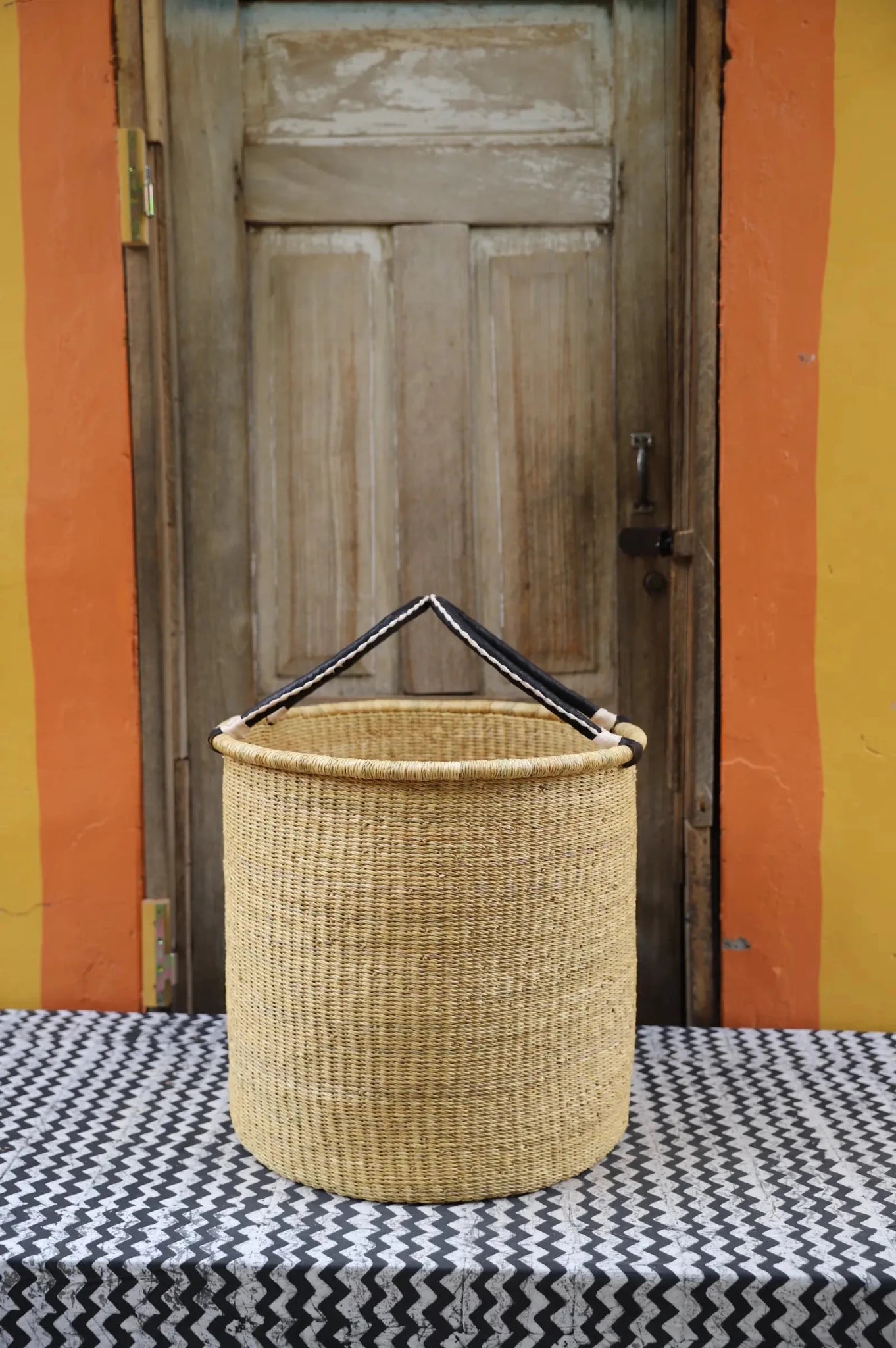 Open Laundry Basket (Large) by The Baba Tree. Handwoven elephant grass storage with leather handles. Bolgatanga artisan decor.