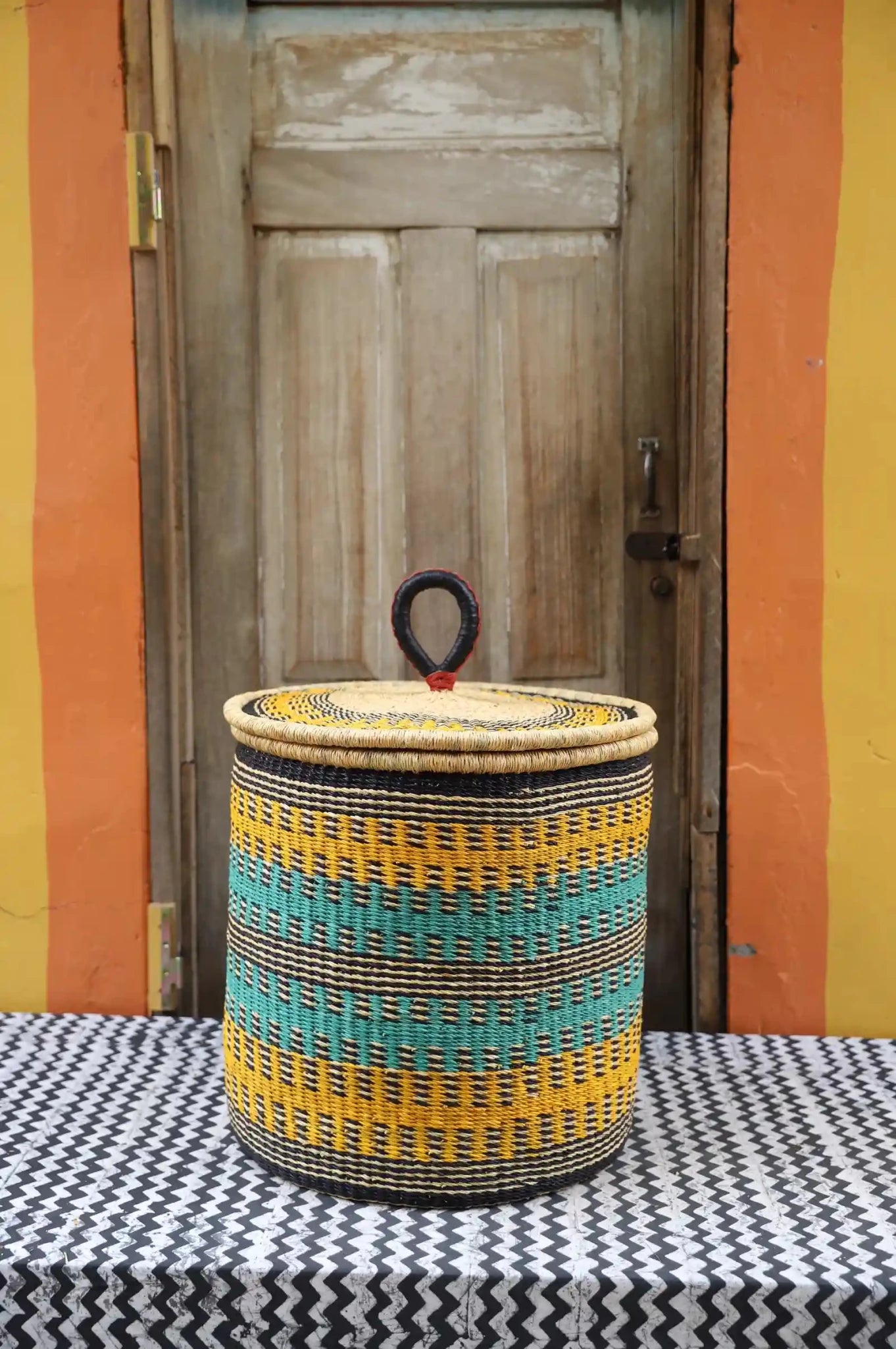 Lidded Laundry Basket with coil (Large) by The Baba Tree. Handwoven elephant grass with leather handle. Premium Bolgatanga artisan decor.