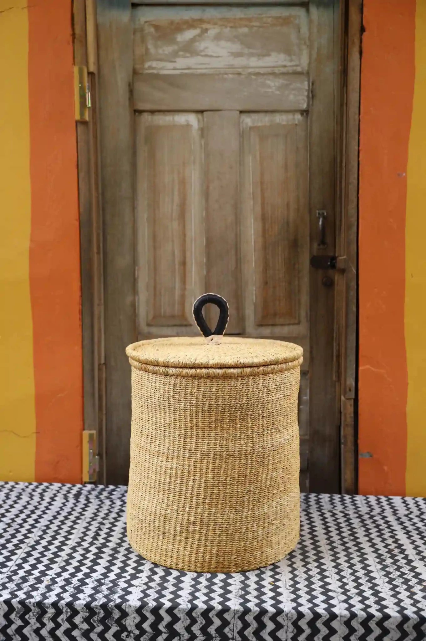 Lidded Laundry Basket with coil (Medium) by The Baba Tree. Handwoven elephant grass with leather handle. Premium Bolgatanga artisan decor.