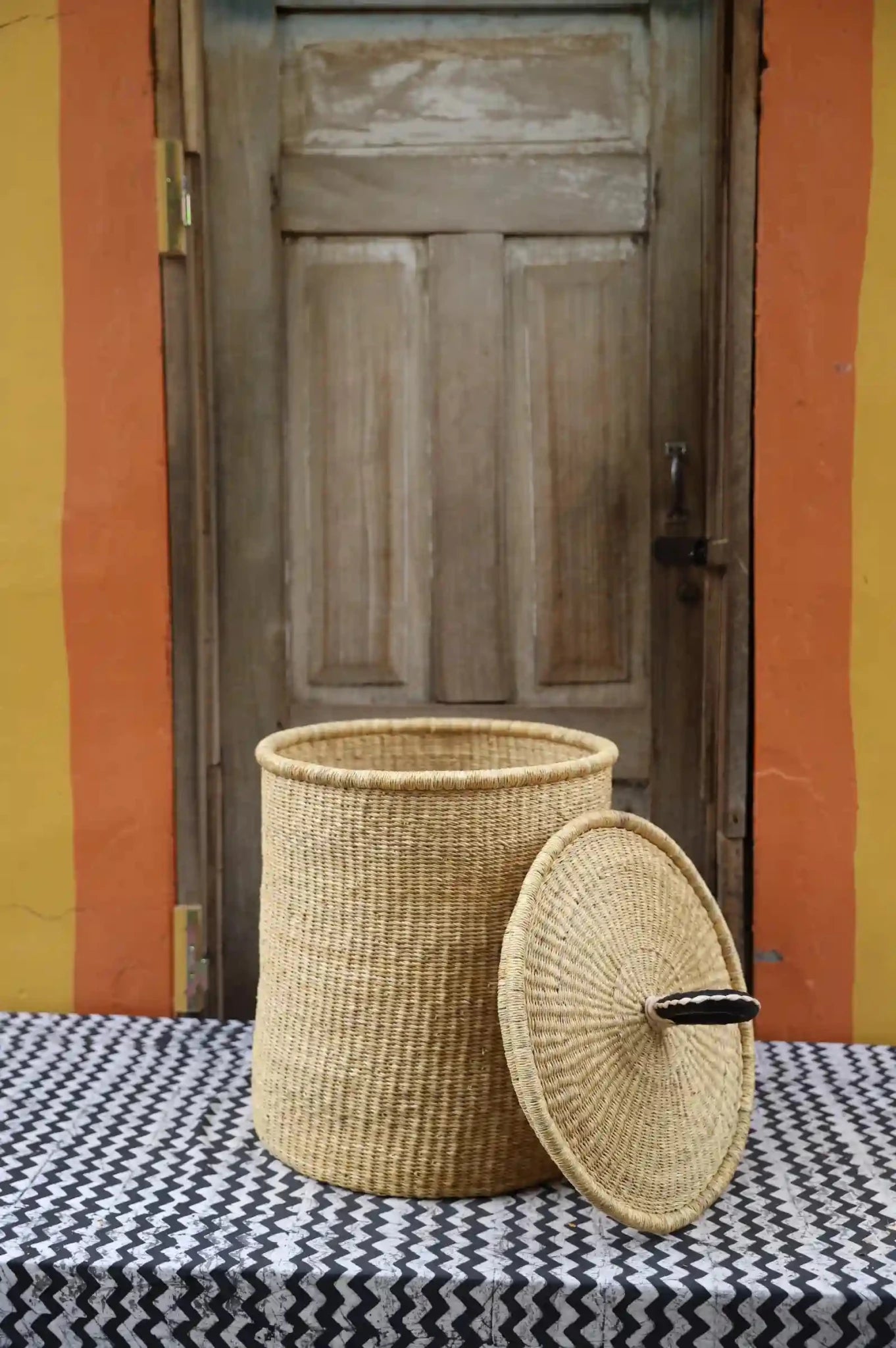 Lidded Laundry Basket with coil (Medium) by The Baba Tree. Handwoven elephant grass with leather handle. Premium Bolgatanga artisan decor.
