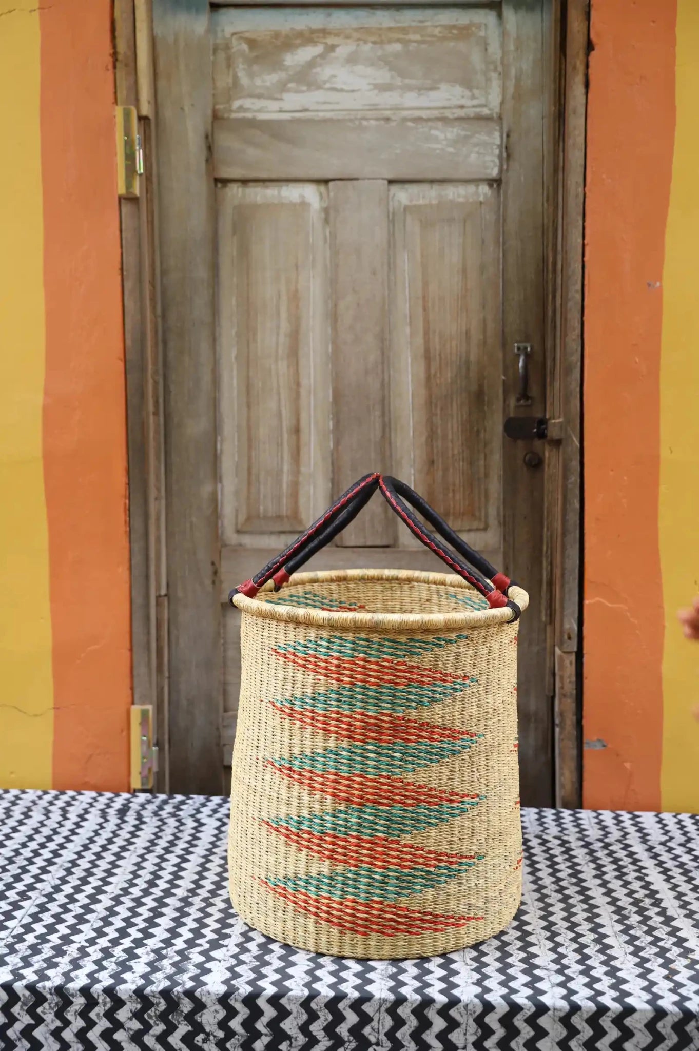 Open Laundry Basket (Medium) by The Baba Tree. Handwoven elephant grass storage with leather handles. Bolgatanga artisan decor.