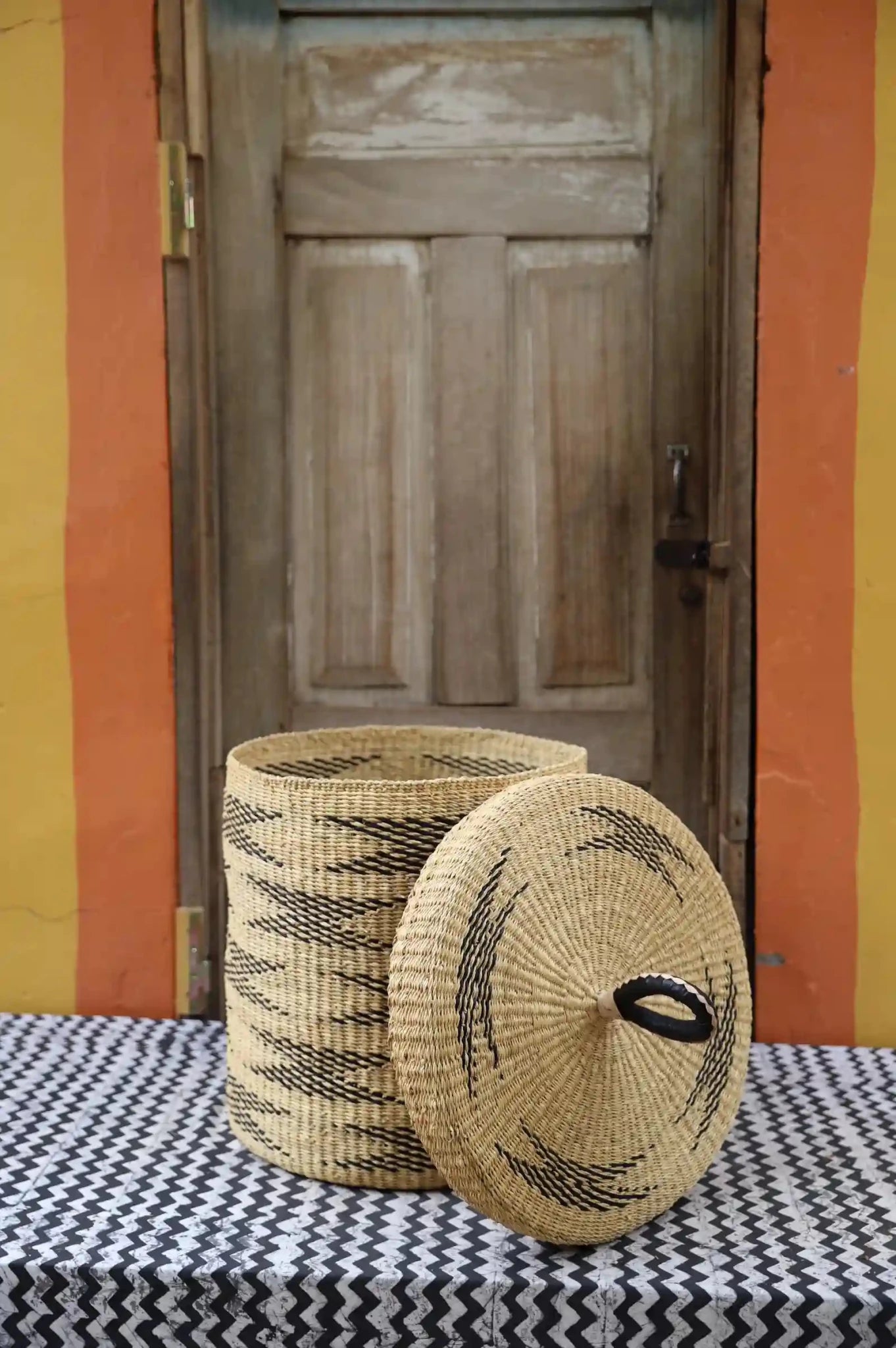 Lidded Laundry Basket (Medium) by The Baba Tree. Handwoven elephant grass with leather handle. Premium Bolgatanga artisan decor.l