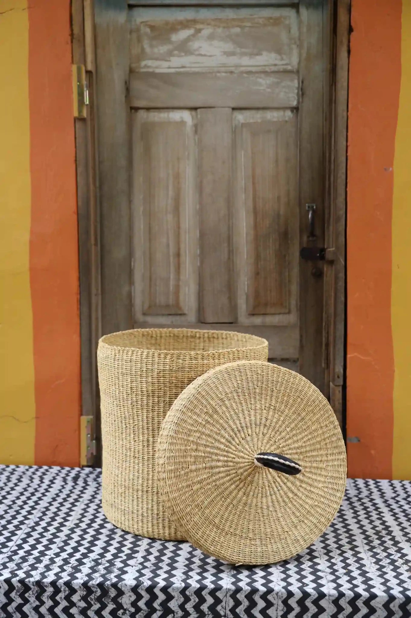 Lidded Laundry Basket (Medium) by The Baba Tree. Handwoven elephant grass with leather handle. Premium Bolgatanga artisan decor.l