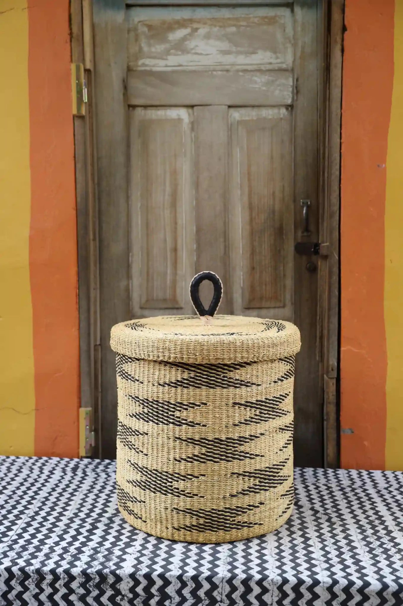 Lidded Laundry Basket (Medium) by The Baba Tree. Handwoven elephant grass with leather handle. Premium Bolgatanga artisan decor.l