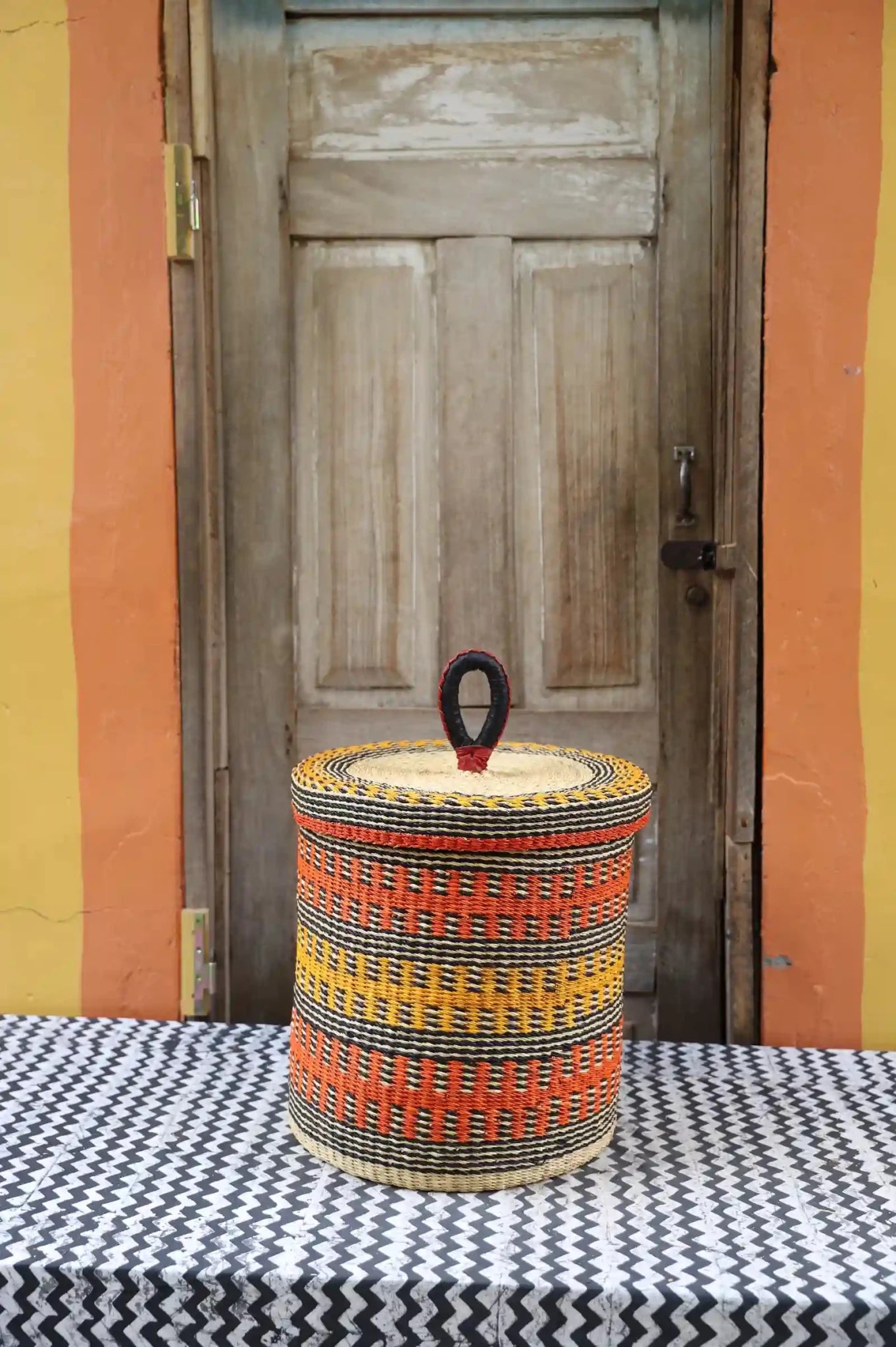 Lidded Laundry Basket  (Small) by The Baba Tree. Handwoven elephant grass
with leather handle. Premium Bolgatanga artisan decor.