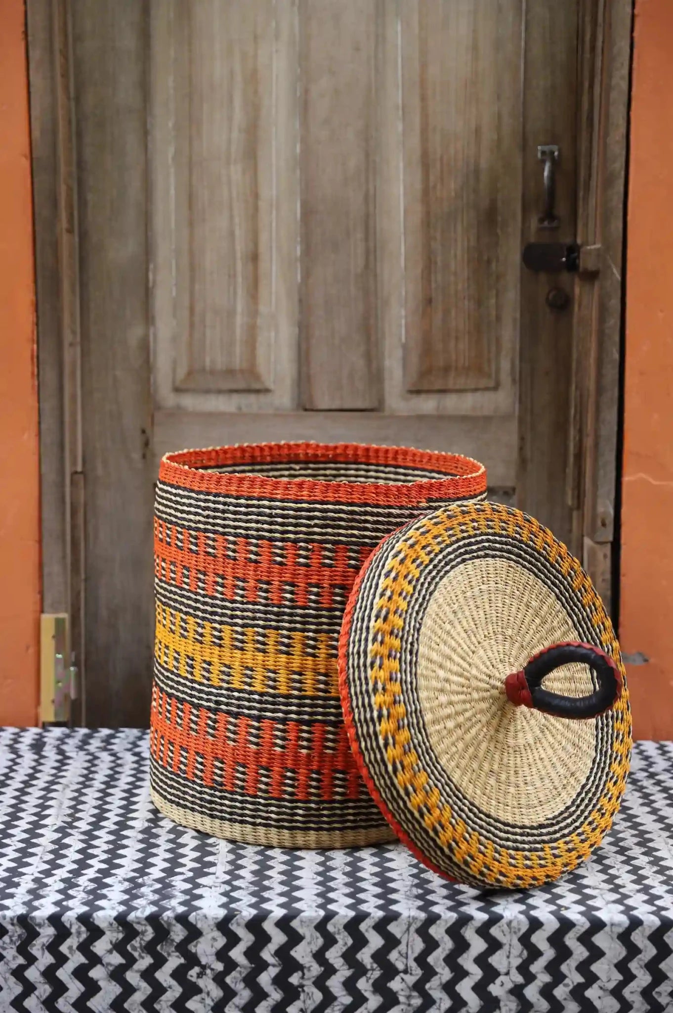 Lidded Laundry Basket  (Small) by The Baba Tree. Handwoven elephant grass
with leather handle. Premium Bolgatanga artisan decor.