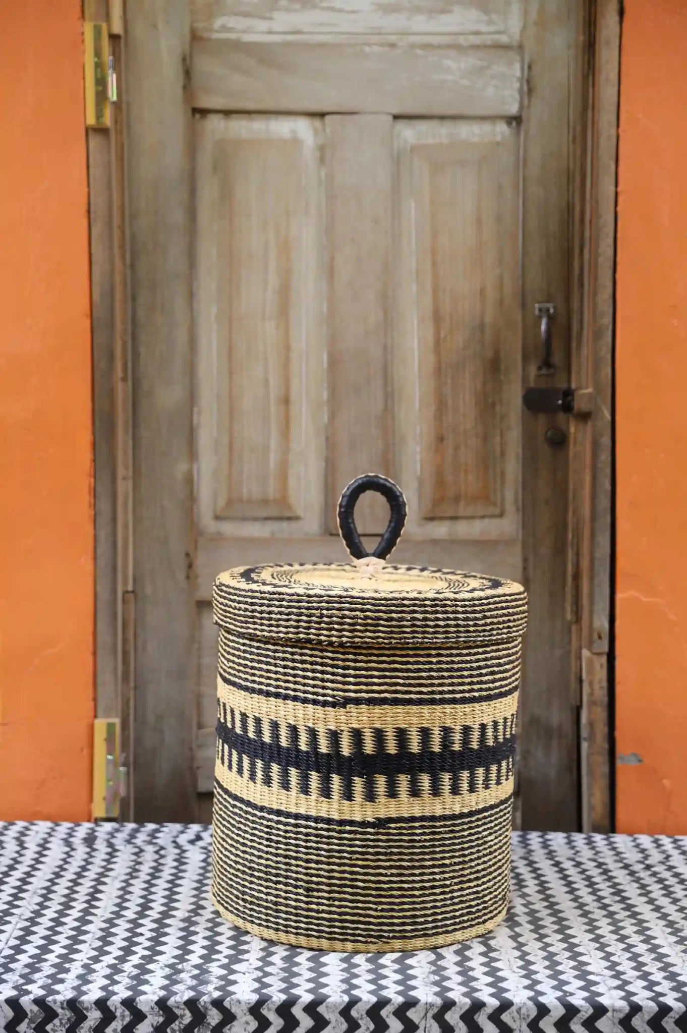Lidded Laundry Basket  (Small) by The Baba Tree. Handwoven elephant grass
with leather handle. Premium Bolgatanga artisan decor.