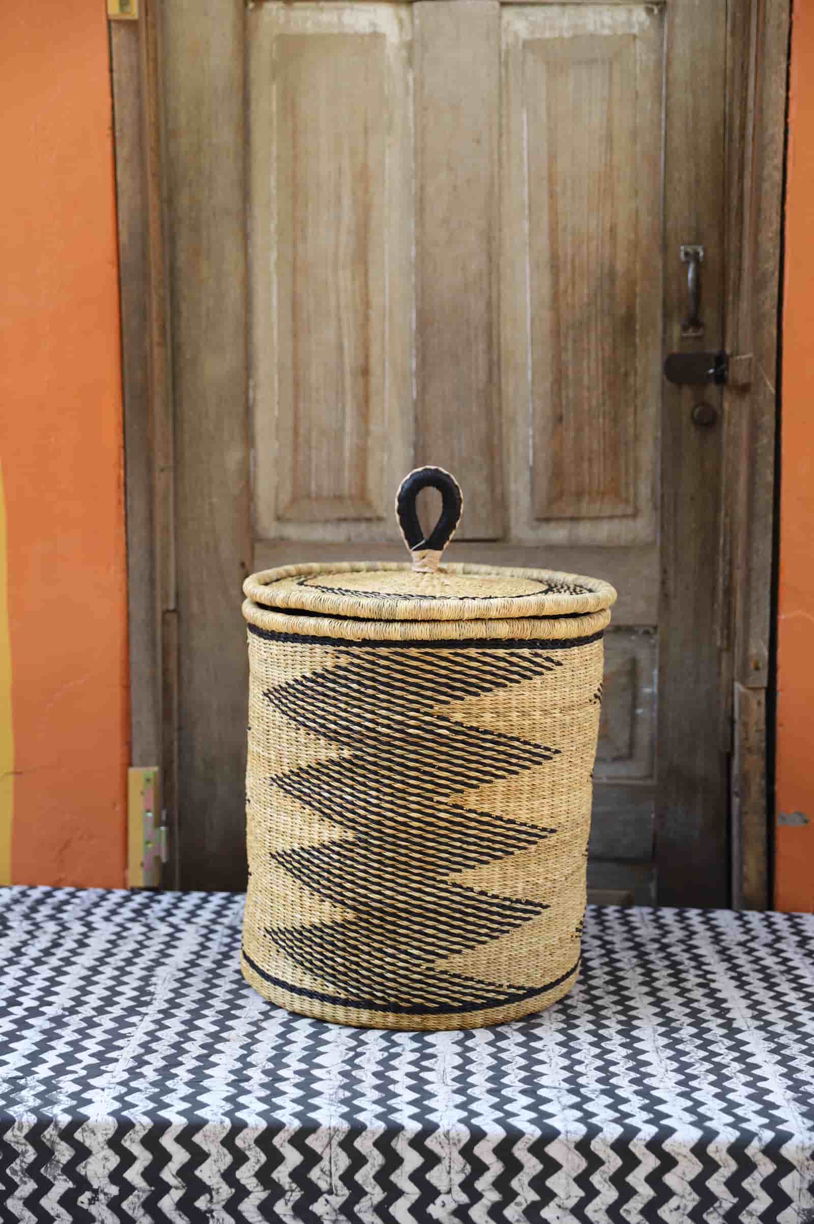 Lidded Laundry Basket with coil (Small) by The Baba Tree. Handwoven elephant grass with leather handle. Premium Bolgatanga artisan decor.