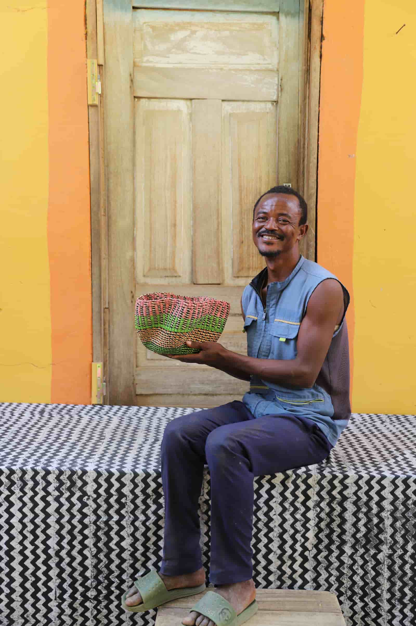 Man holding tiny Pakurigo Wave Décor Basket with pink and lime green wave-stripe pattern
