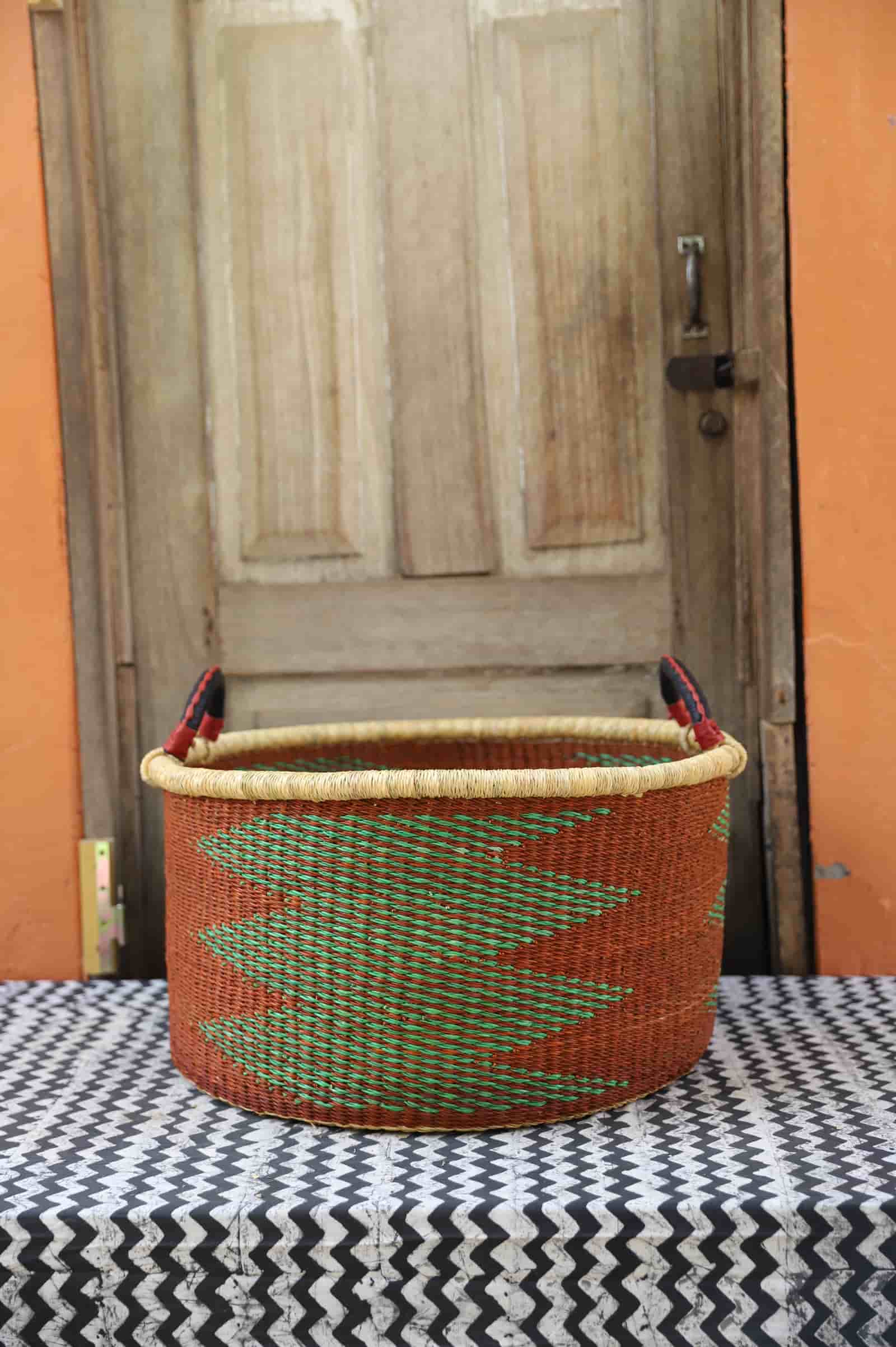 Woven Tub (Large) handwoven in Ghana sitting on black and white cloth with wooden door background