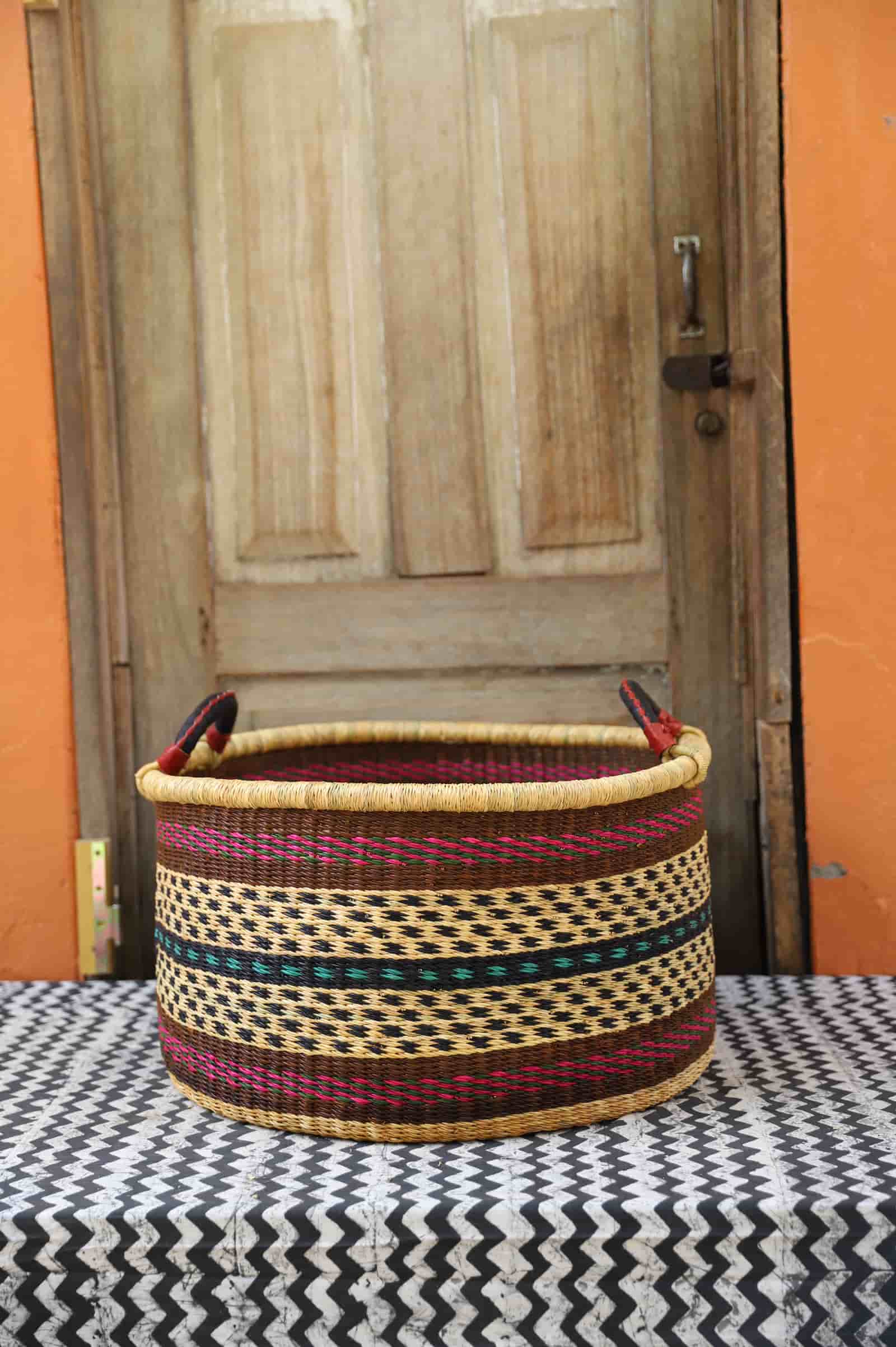 Woven Tub (Large) handwoven in Ghana sitting on black and white cloth with wooden door background