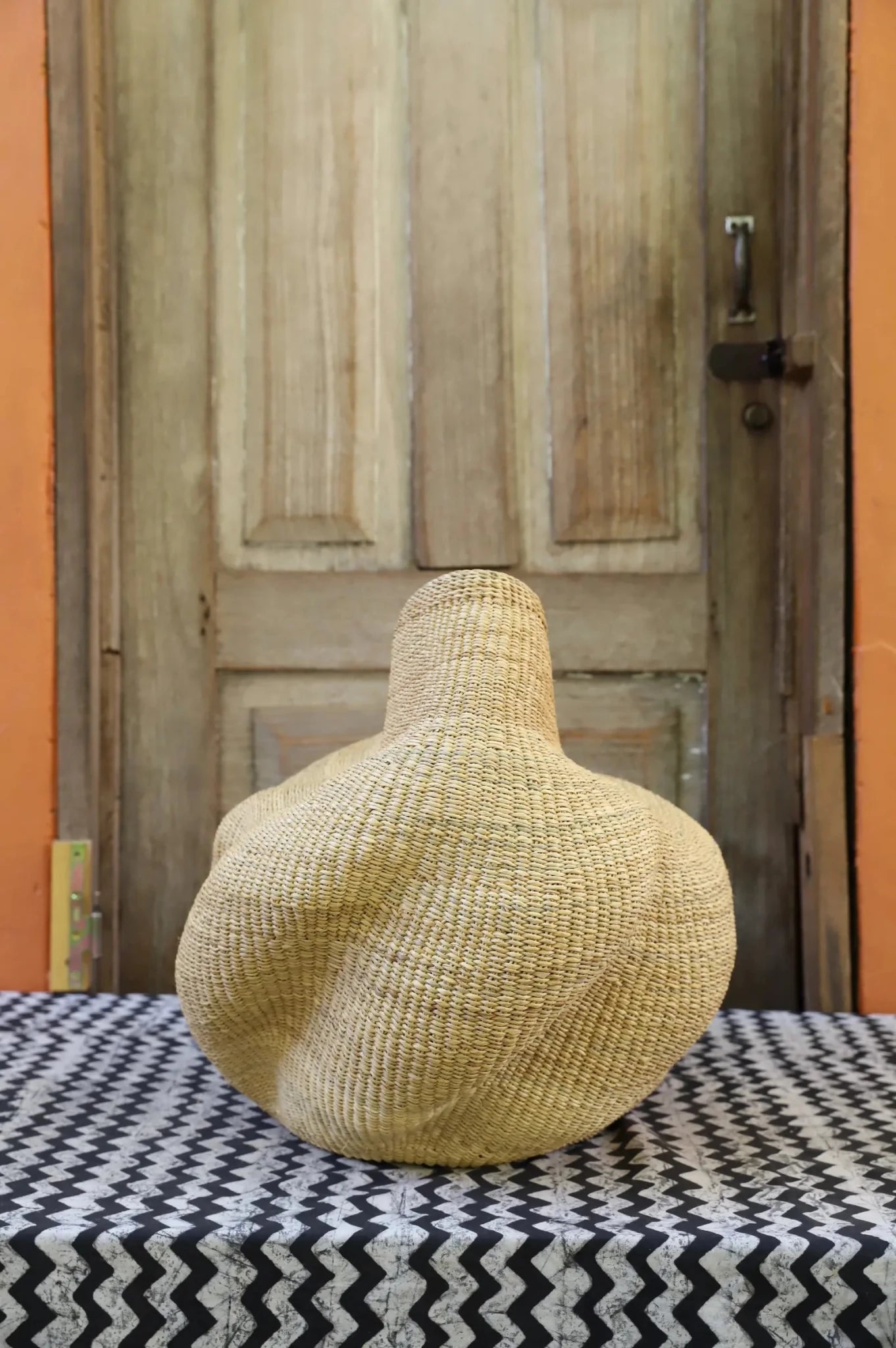 Decorative basket on a black and white cloth against a wooden door.