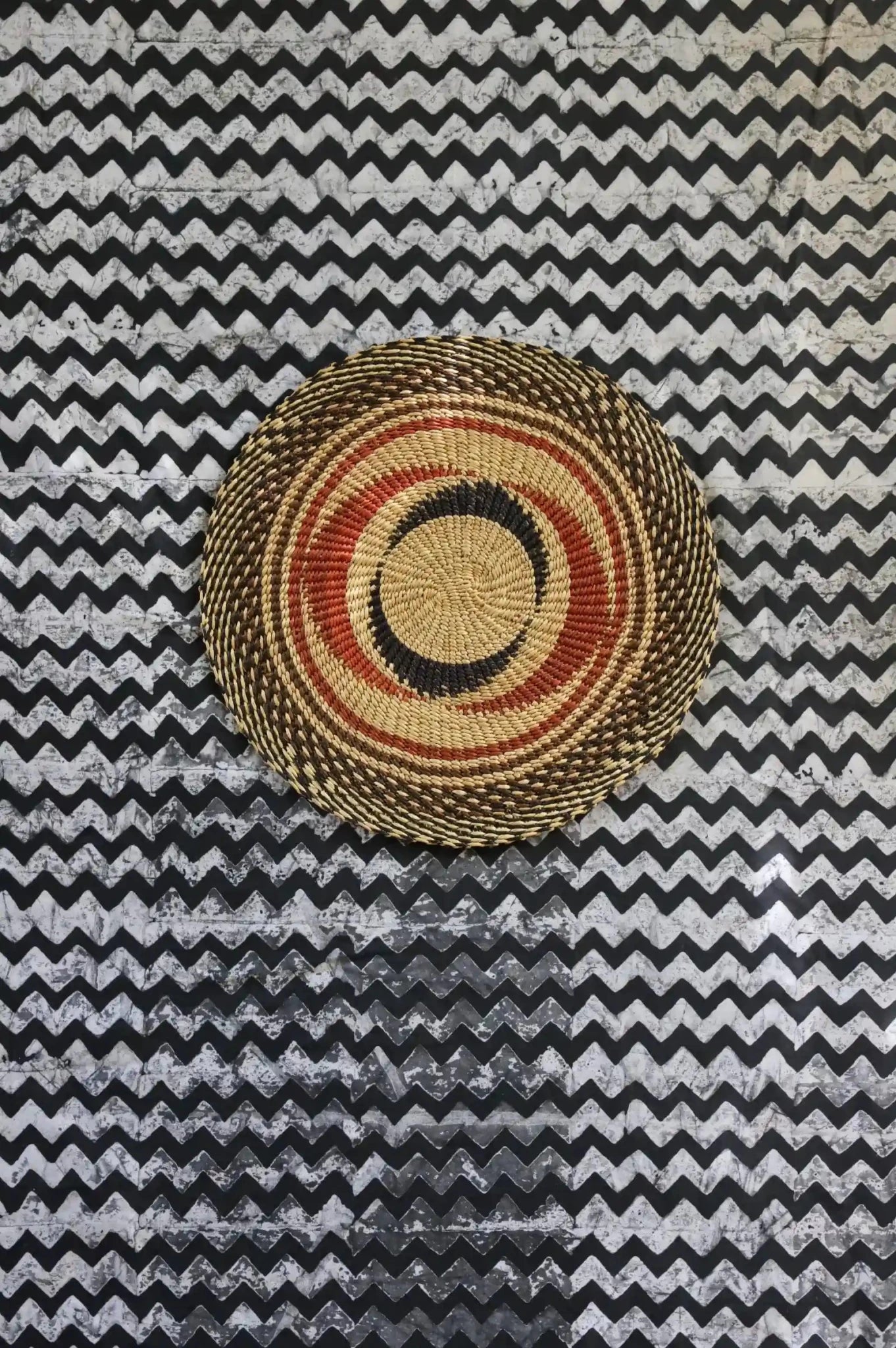 Woven placemat for dining on a black and white cloth