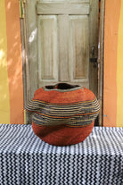 Textured woven basket on a table with a wooden door in the background