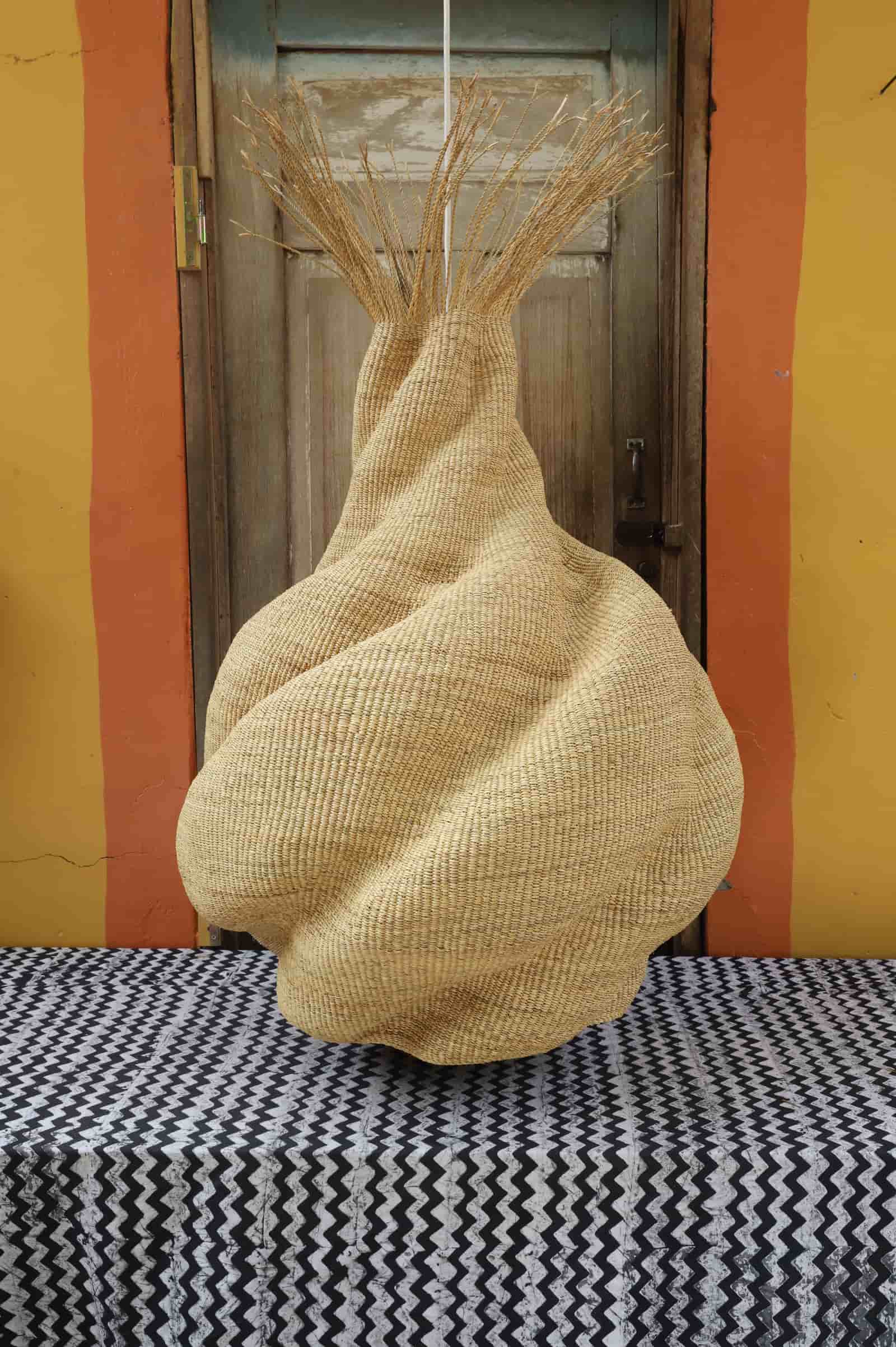 Textured woven  basket  on a black and white patterned tablecloth with a striped wall background