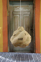 Woven basket hanging in front of a wooden door with a colorful wall background