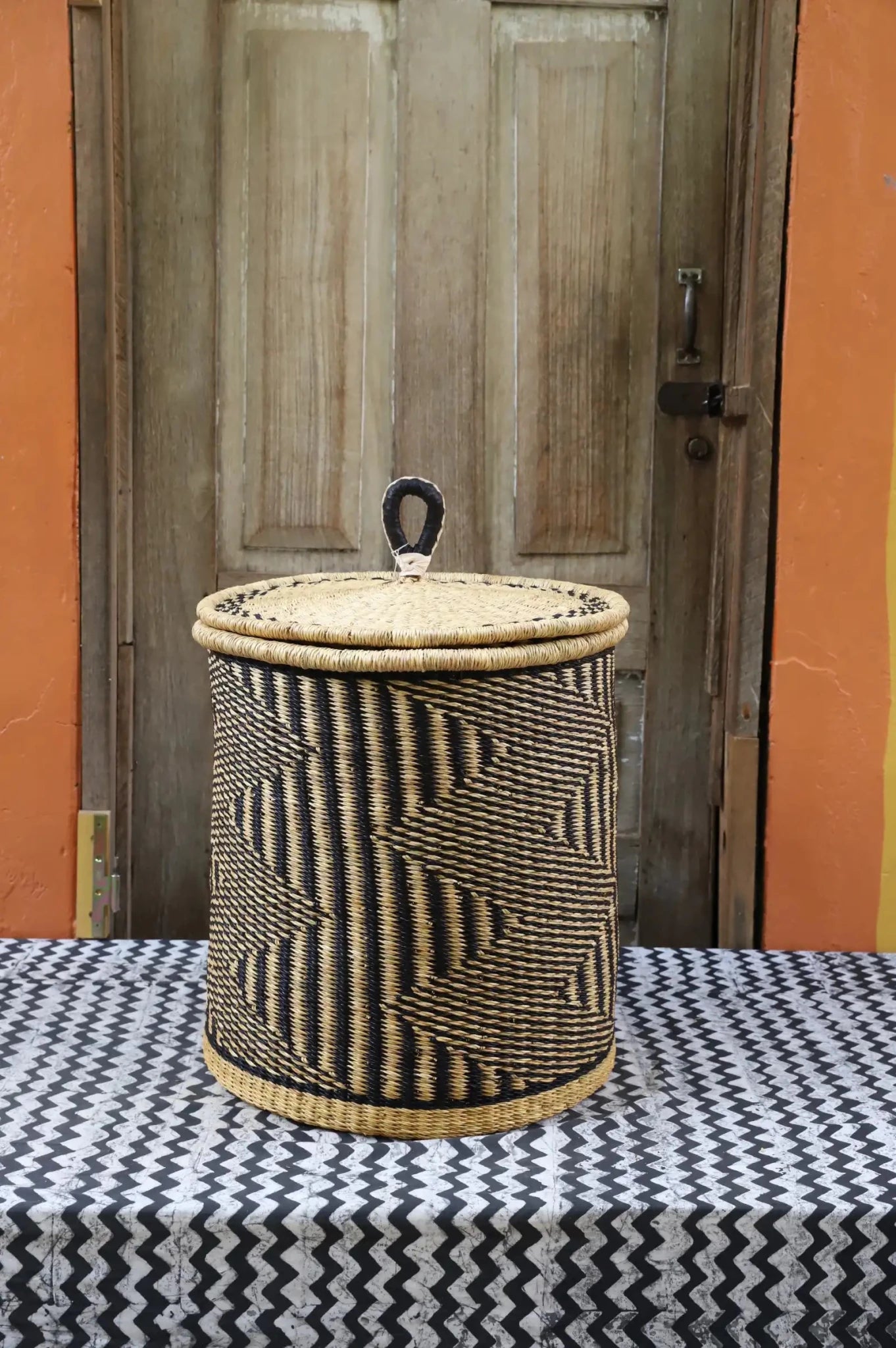 Lidded Laundry Basket with coil (Small) by The Baba Tree. Handwoven elephant grass with leather handle. Premium Bolgatanga artisan decor.
