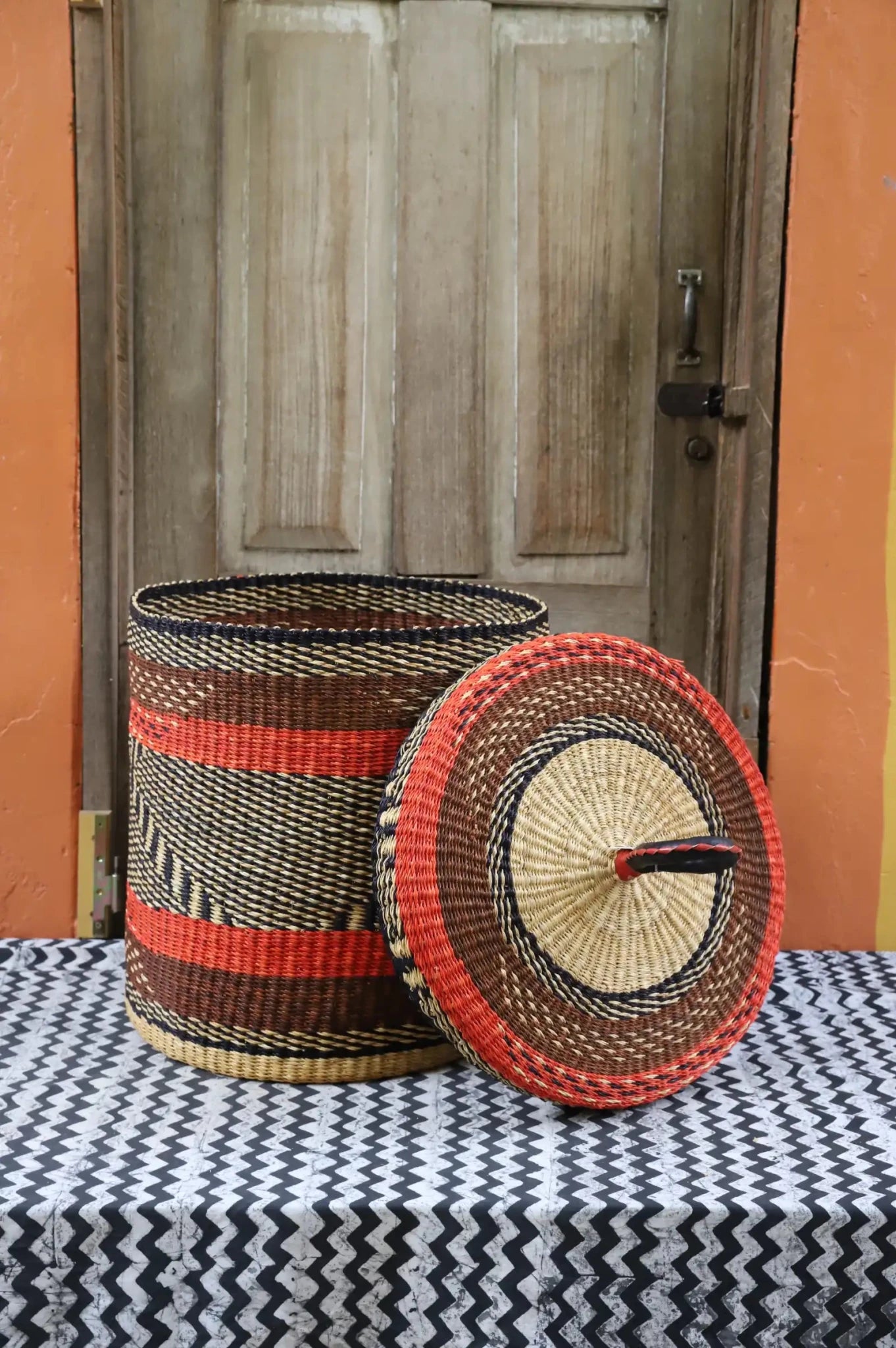 Lidded Laundry Basket (Medium) by The Baba Tree. Handwoven elephant grass with leather handle. Premium Bolgatanga artisan decor.