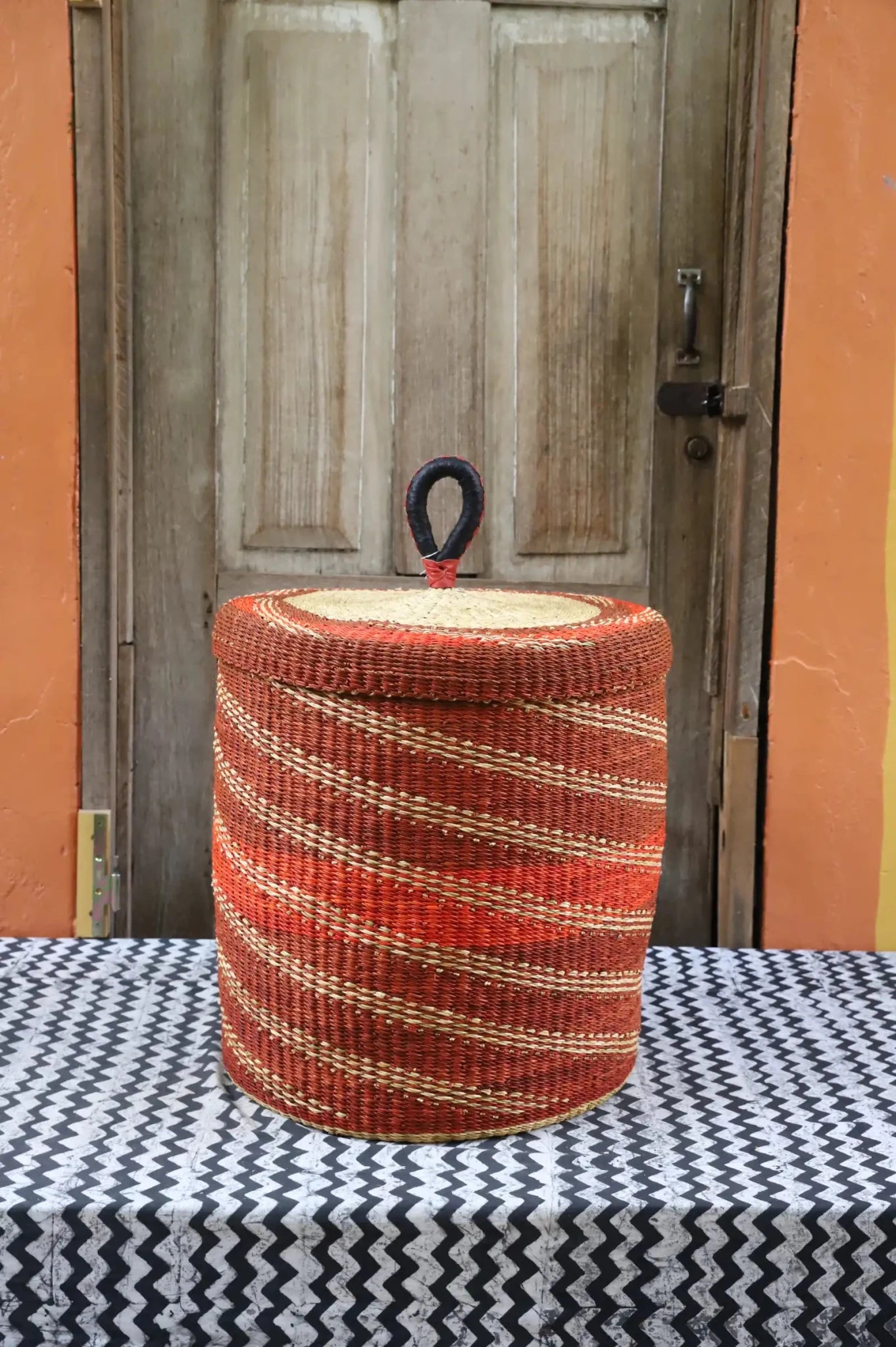 Lidded Laundry Basket (Medium) by The Baba Tree. Handwoven elephant grass with leather handle. Premium Bolgatanga artisan decor.