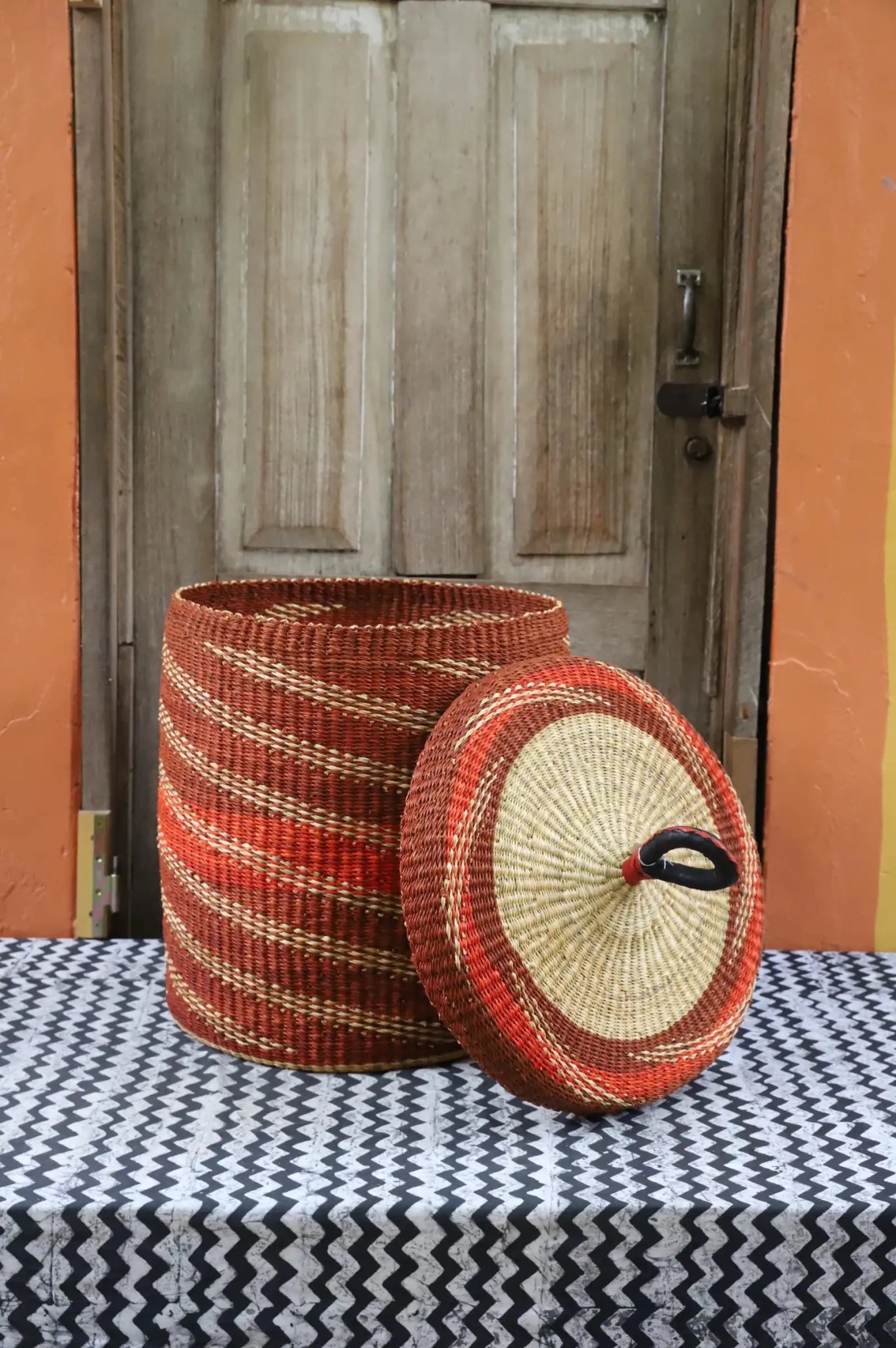 Lidded Laundry Basket (Medium) by The Baba Tree. Handwoven elephant grass with leather handle. Premium Bolgatanga artisan decor.