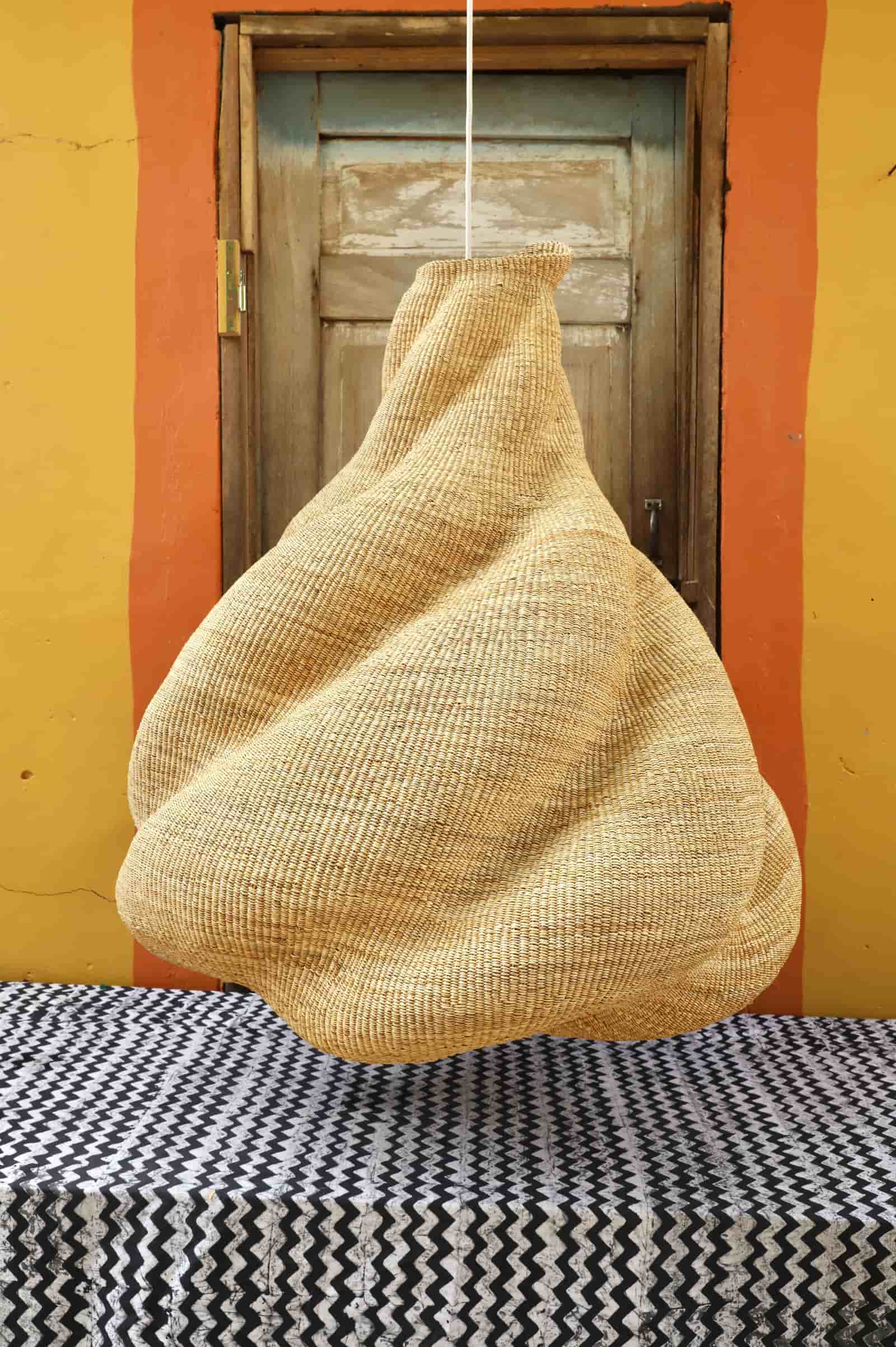 Woven basket  hanging against a colorful wall with a wooden door.