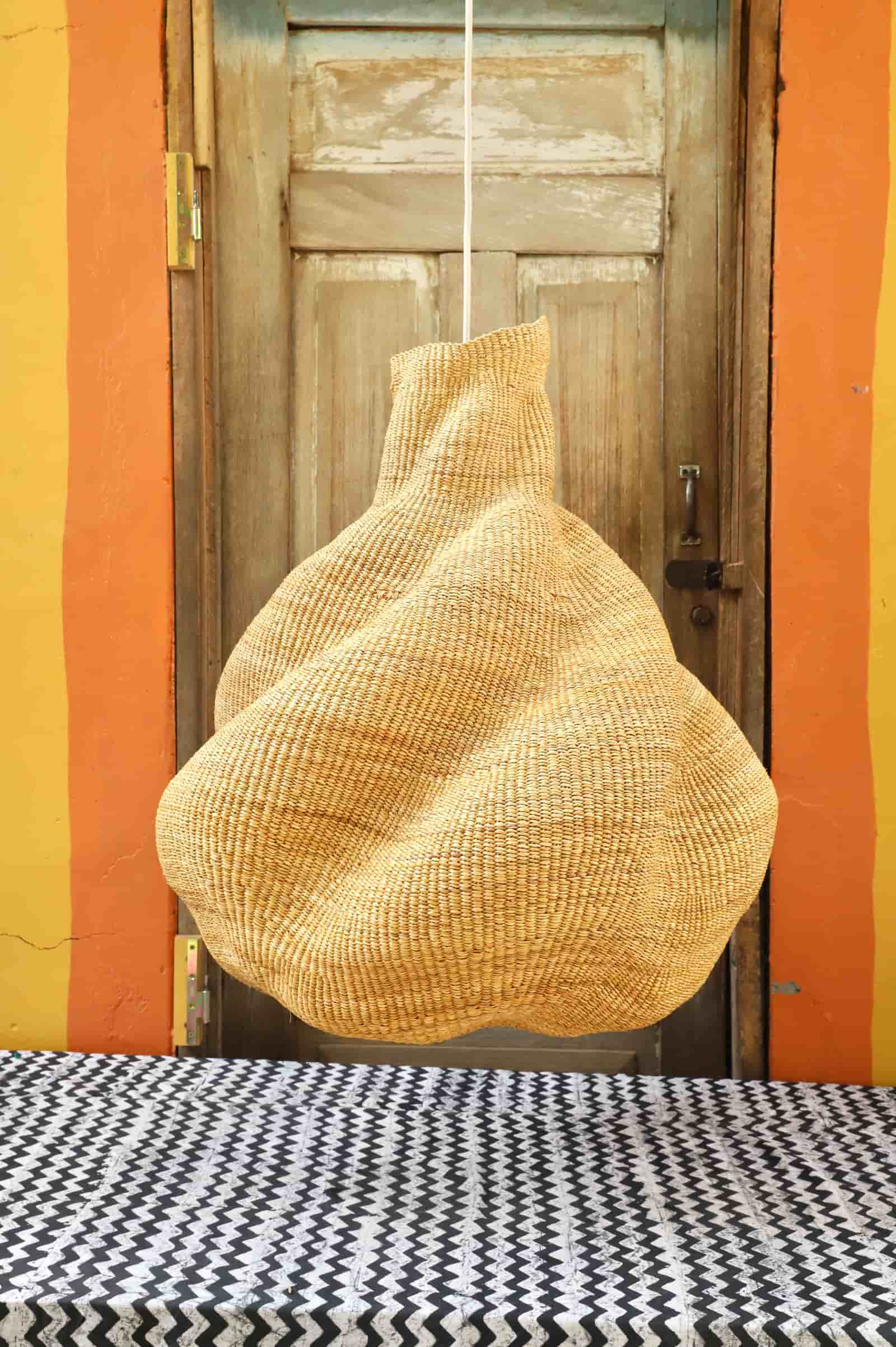 Woven basket hanging on a wooden door with a colorful wall background