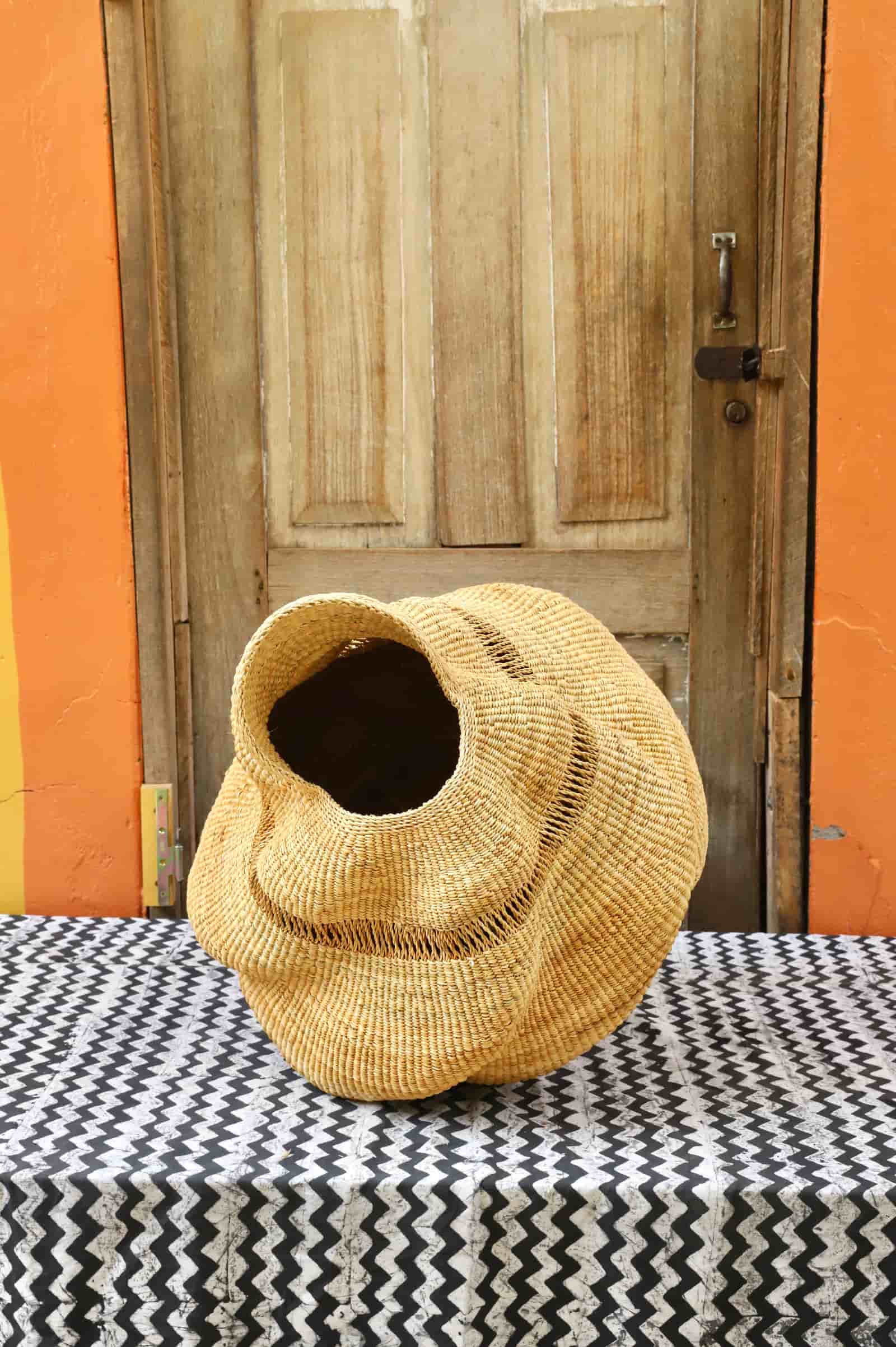 Conch-shaped lampshade on a black and white cloth against a wooden door.