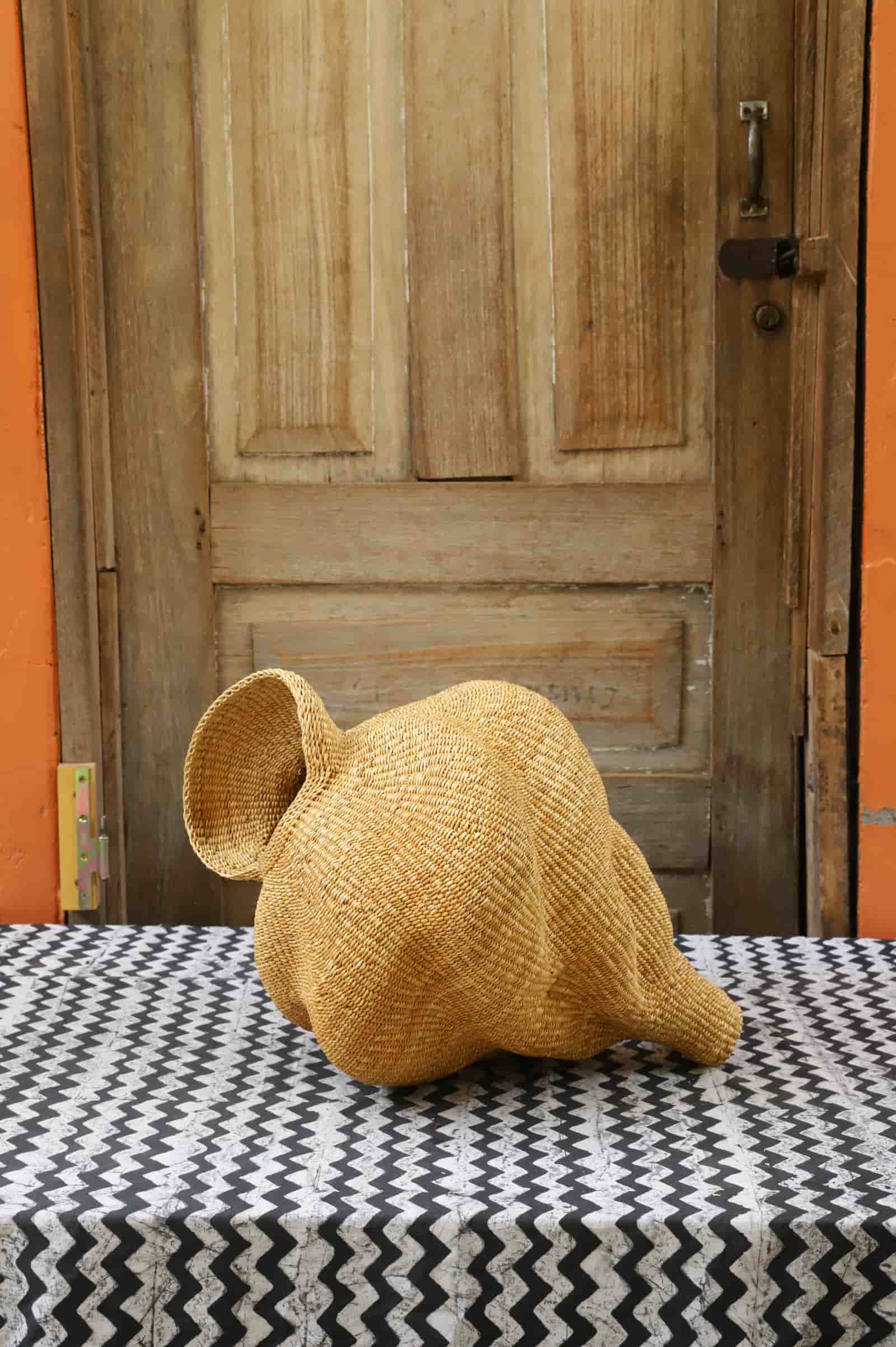 Conch-shaped lampshade on a black and white cloth against a wooden door.