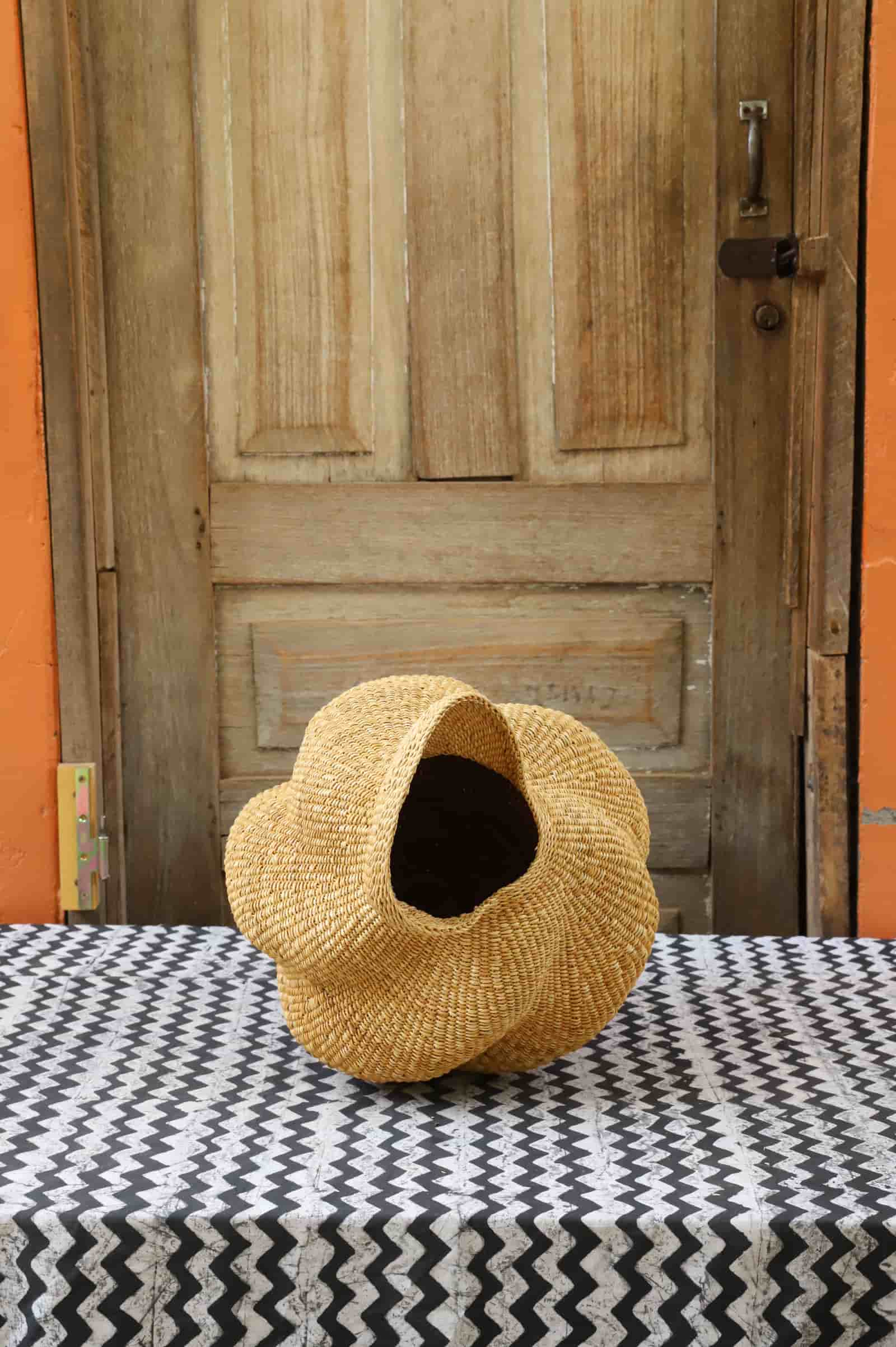 Conch-shaped lampshade in front of a wooden door.