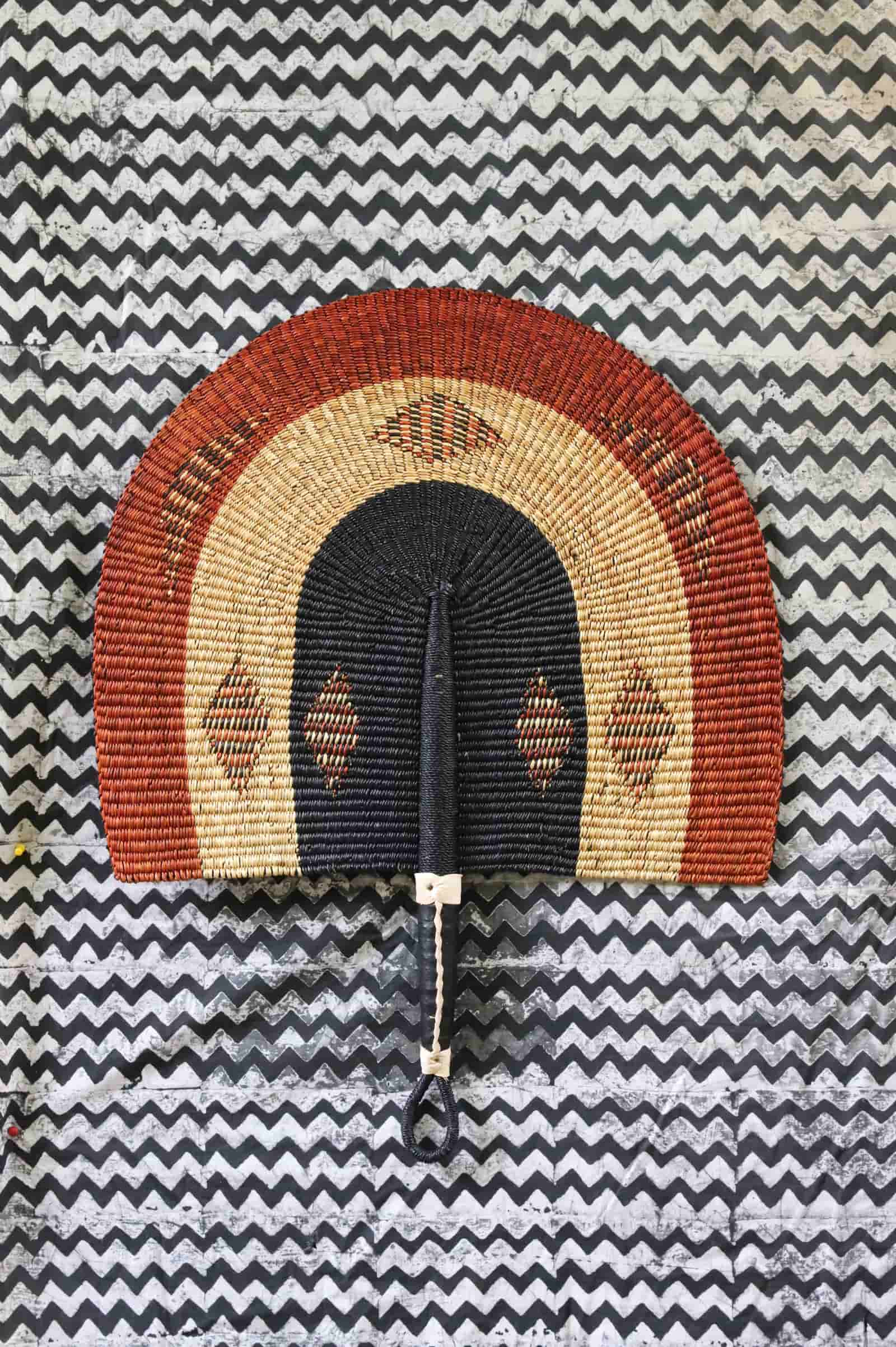 The Baba Tree Bolga Original Fan: Handwoven architectural wall art with intricate weave and premium leather handle.