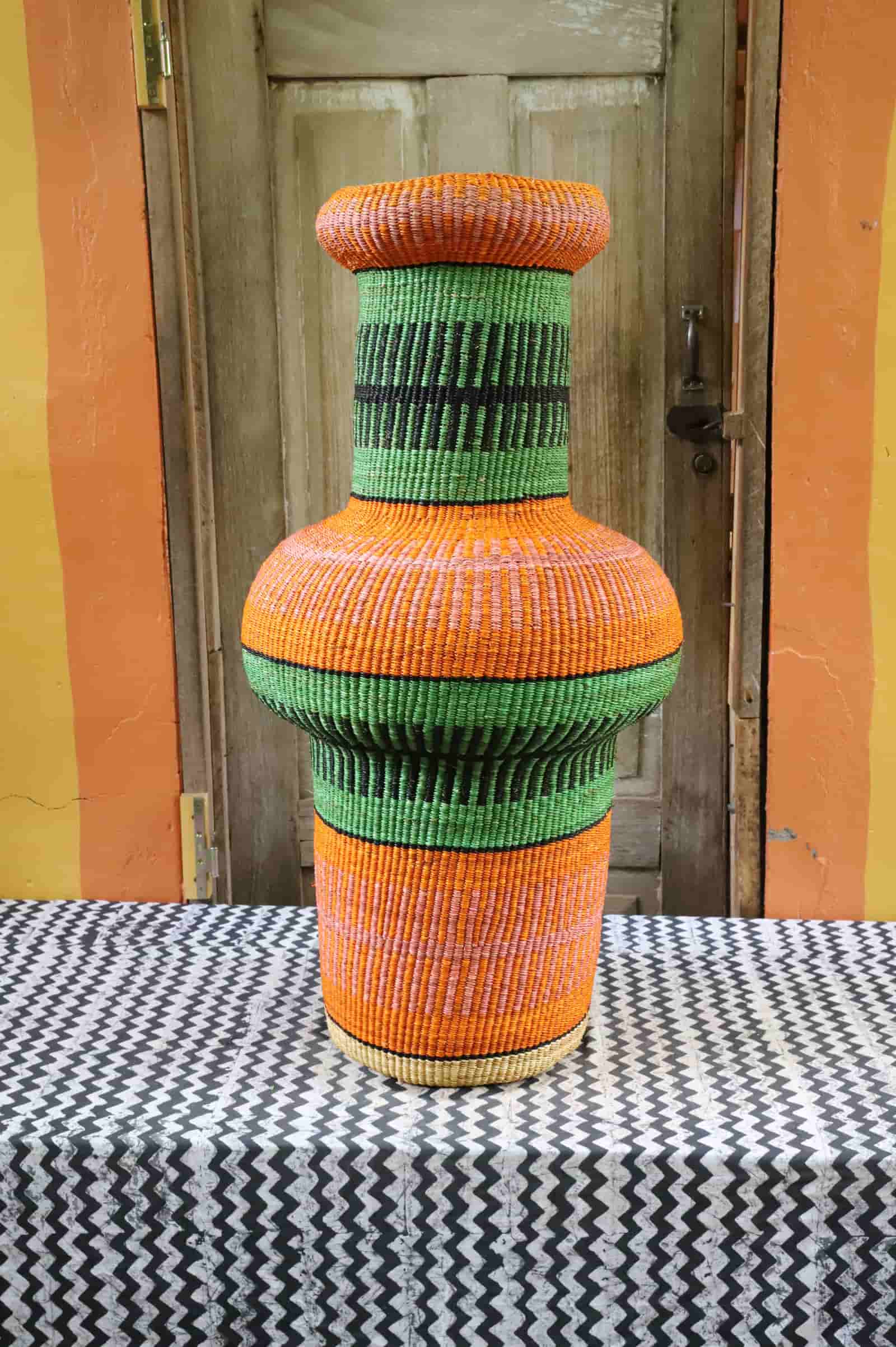 Colorful, woven décor piece on a black and white cloth against a wooden door.