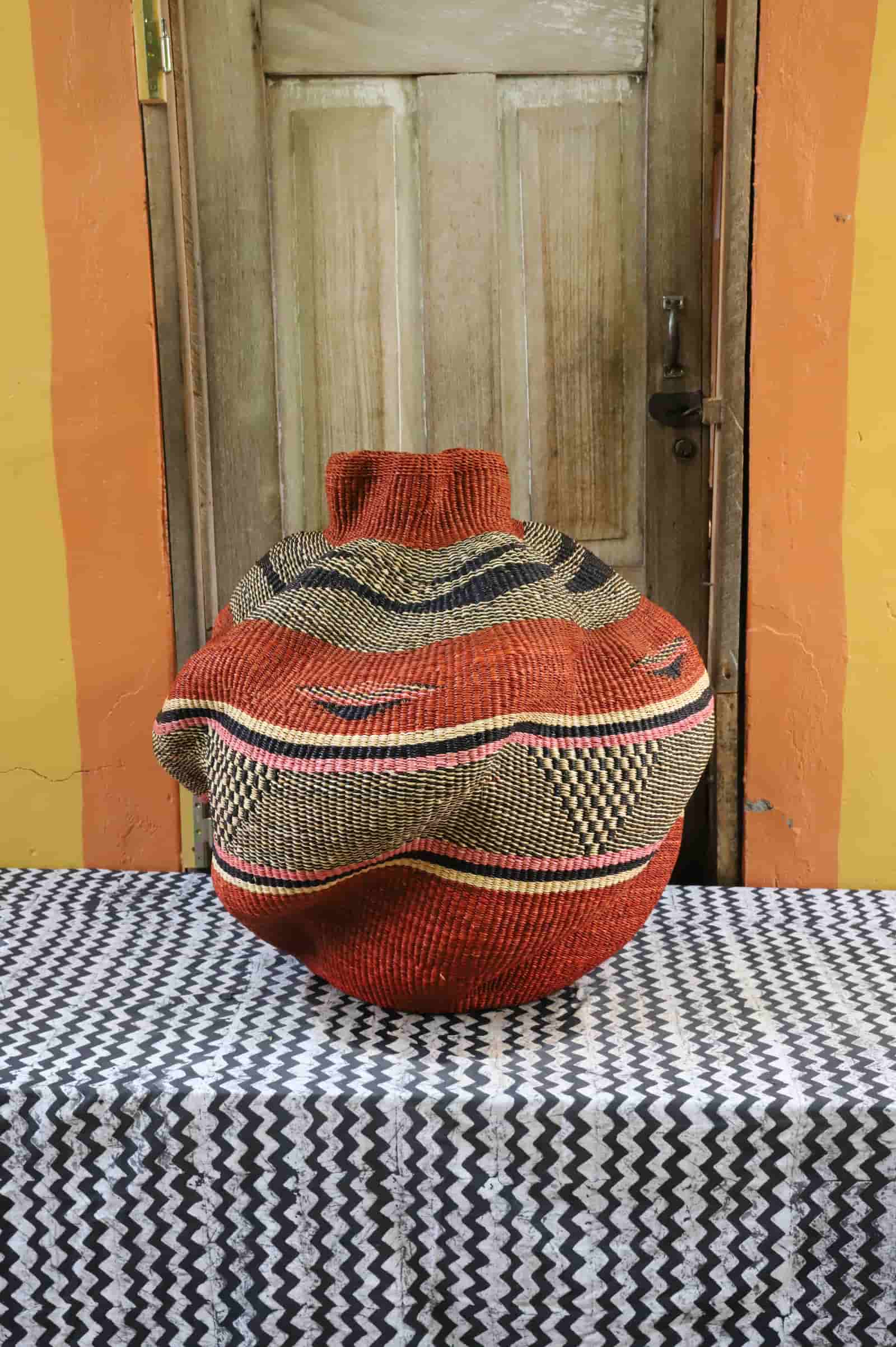 Decorative basket  on a black and white cloth against a wooden door.